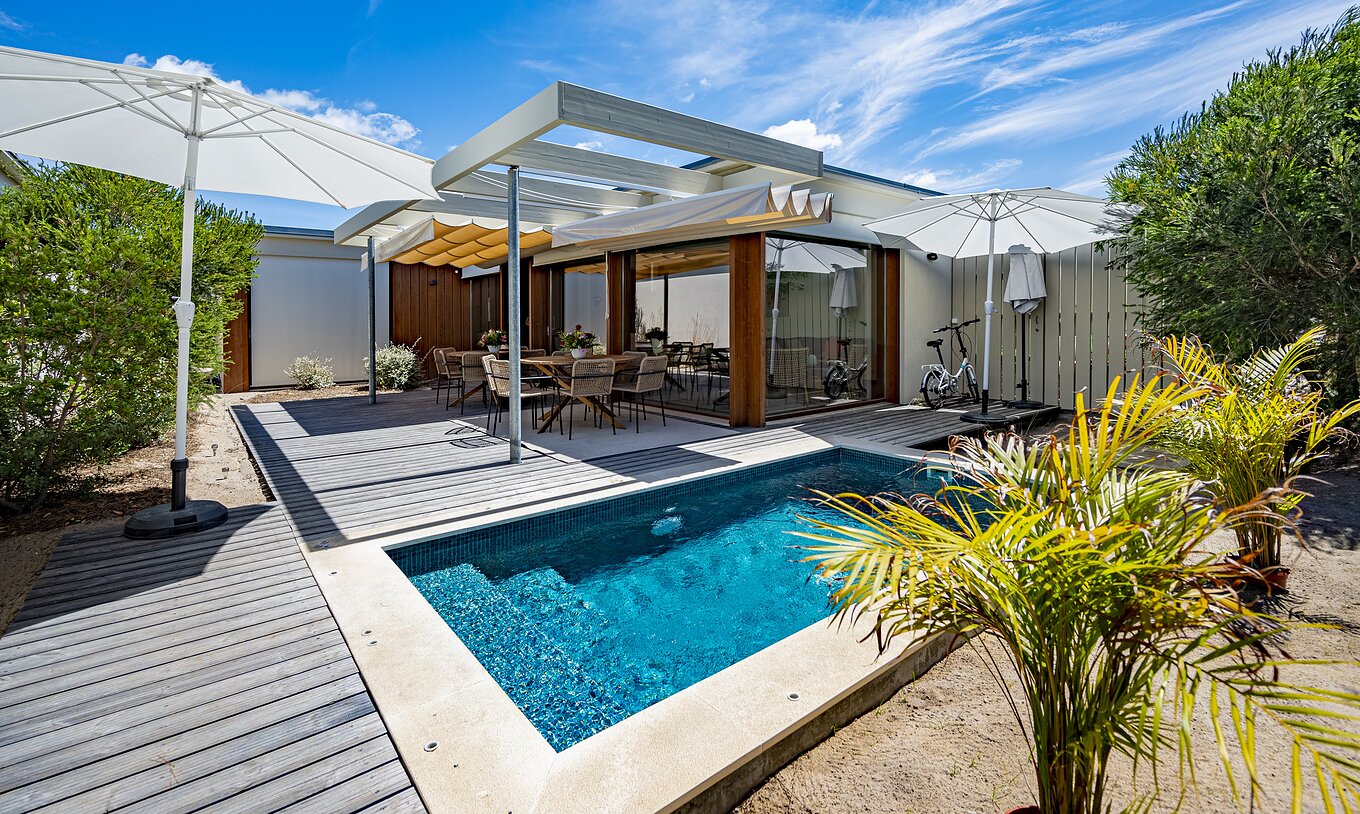 The Aqua Villa of Pestana Tróia Eco Resort has a private pool with a table and chairs beside