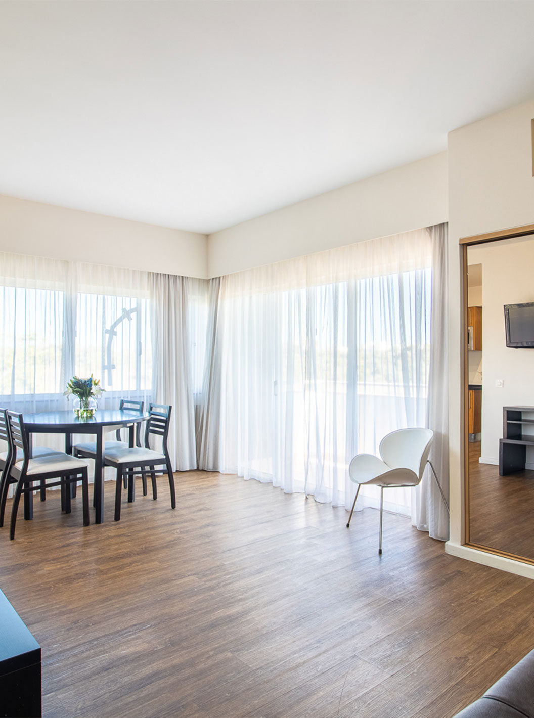 The T1 Garden View Apartment at Pestana Alvor Atlântico has a sofa with a TV and a wardrobe with a mirror