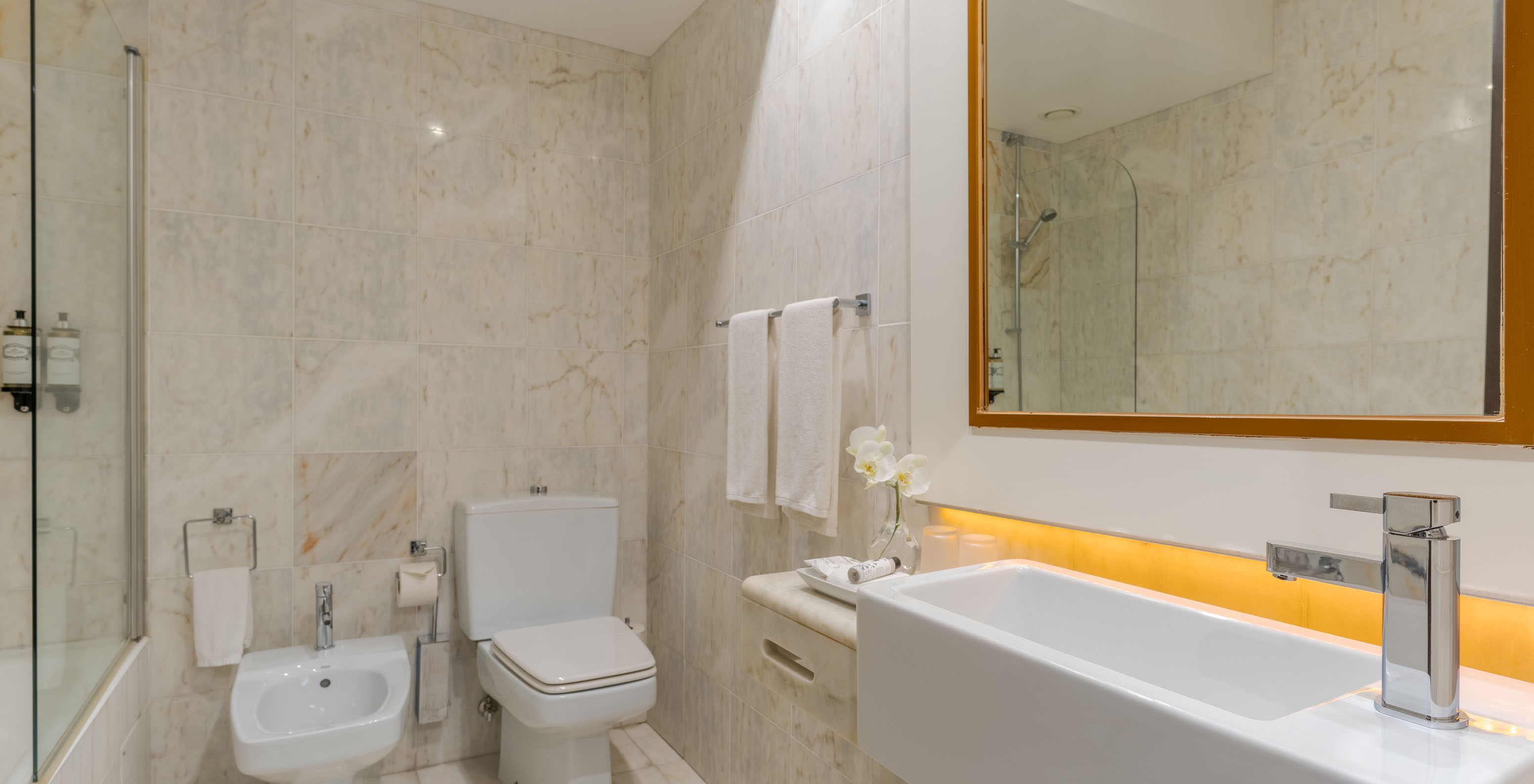 The Deluxe at Pestana Alvor Praia has a light marble bathroom with sink, mirror, toilet, bidet, and bathtub