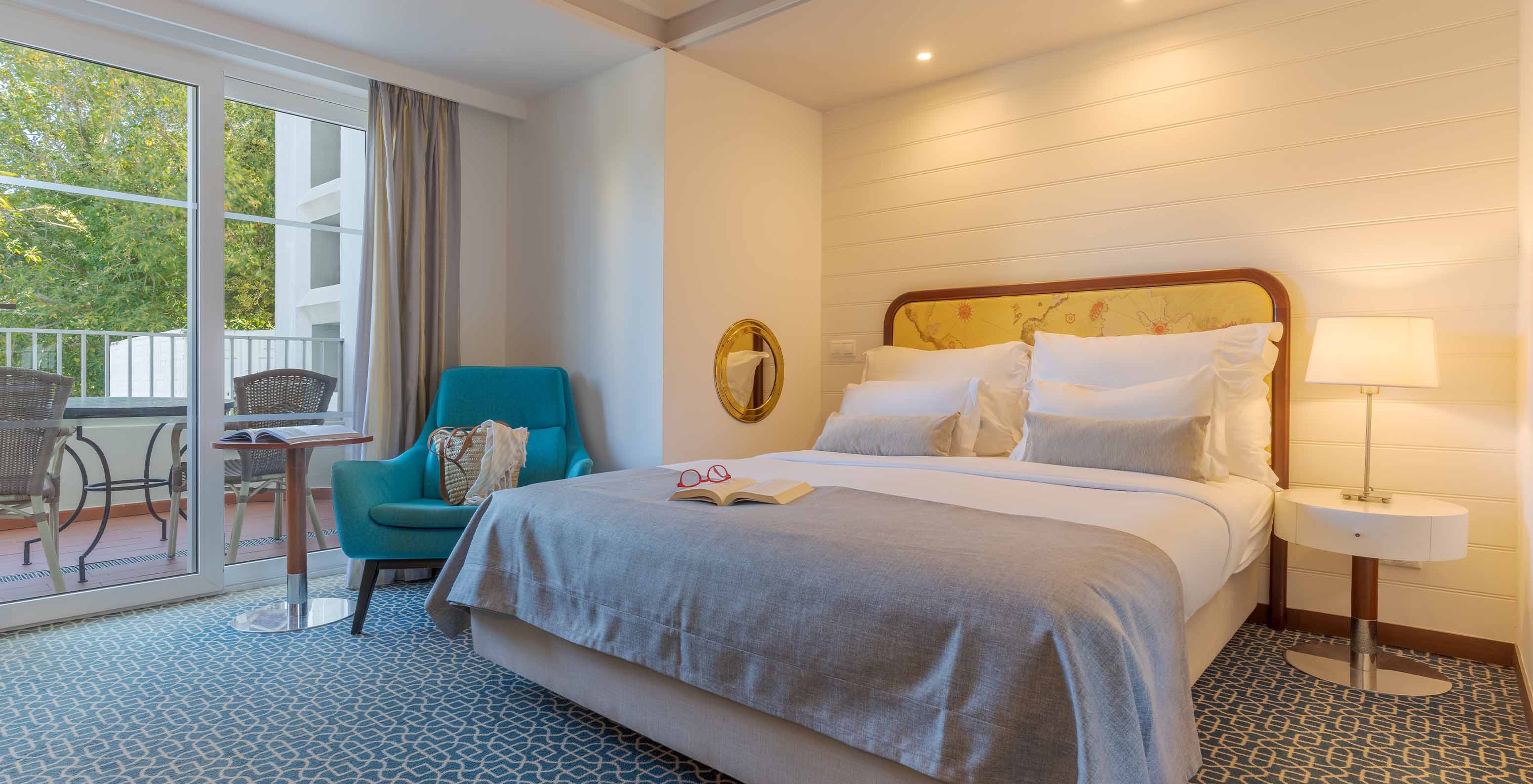 The Garden View Deluxe at Pestana Alvor Praia has a marble bathroom with a sink, mirror, toilet, and bathtub