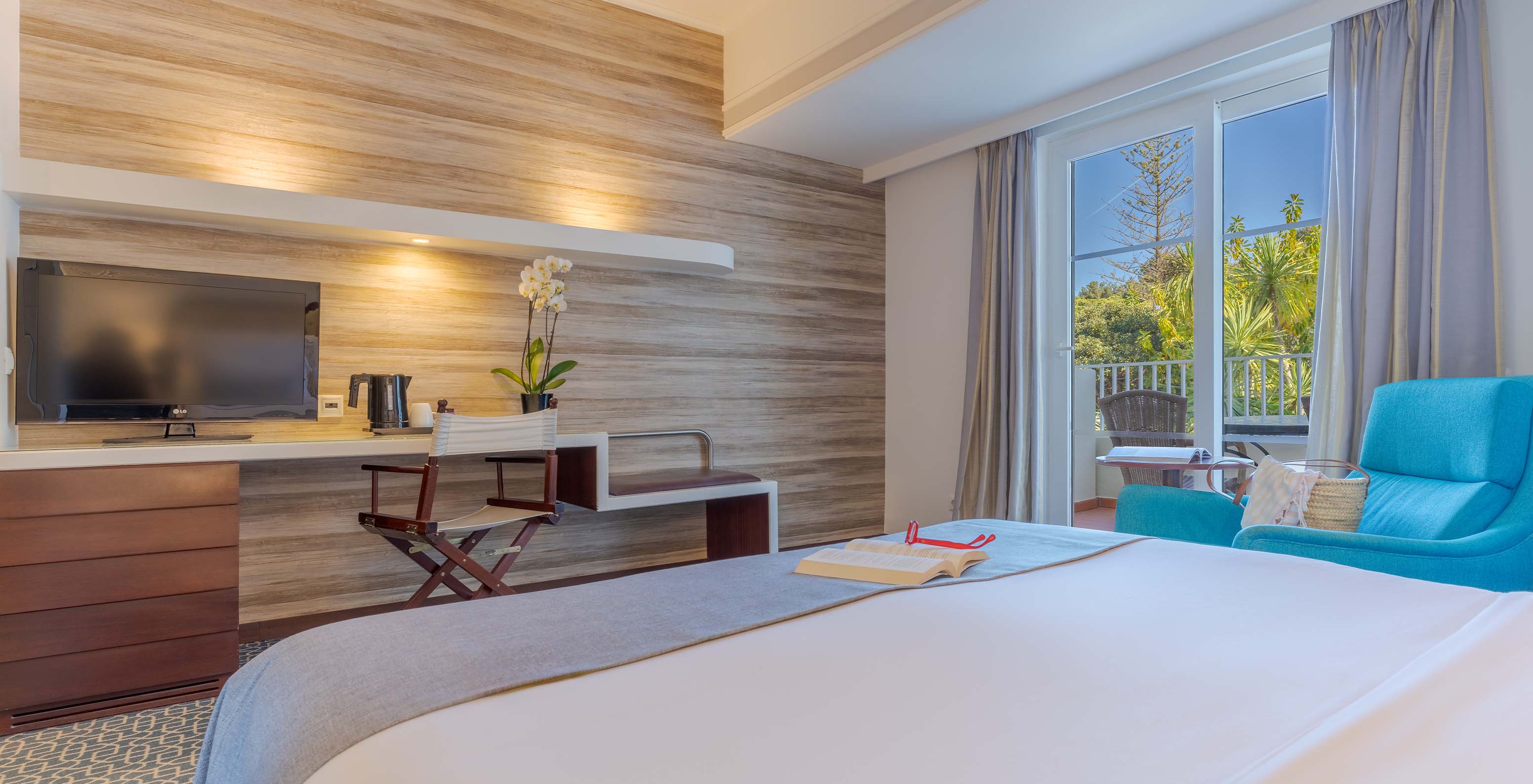 The Garden View Deluxe at Pestana Alvor Praia has a double bed, a desk TV, an armchair, and a window