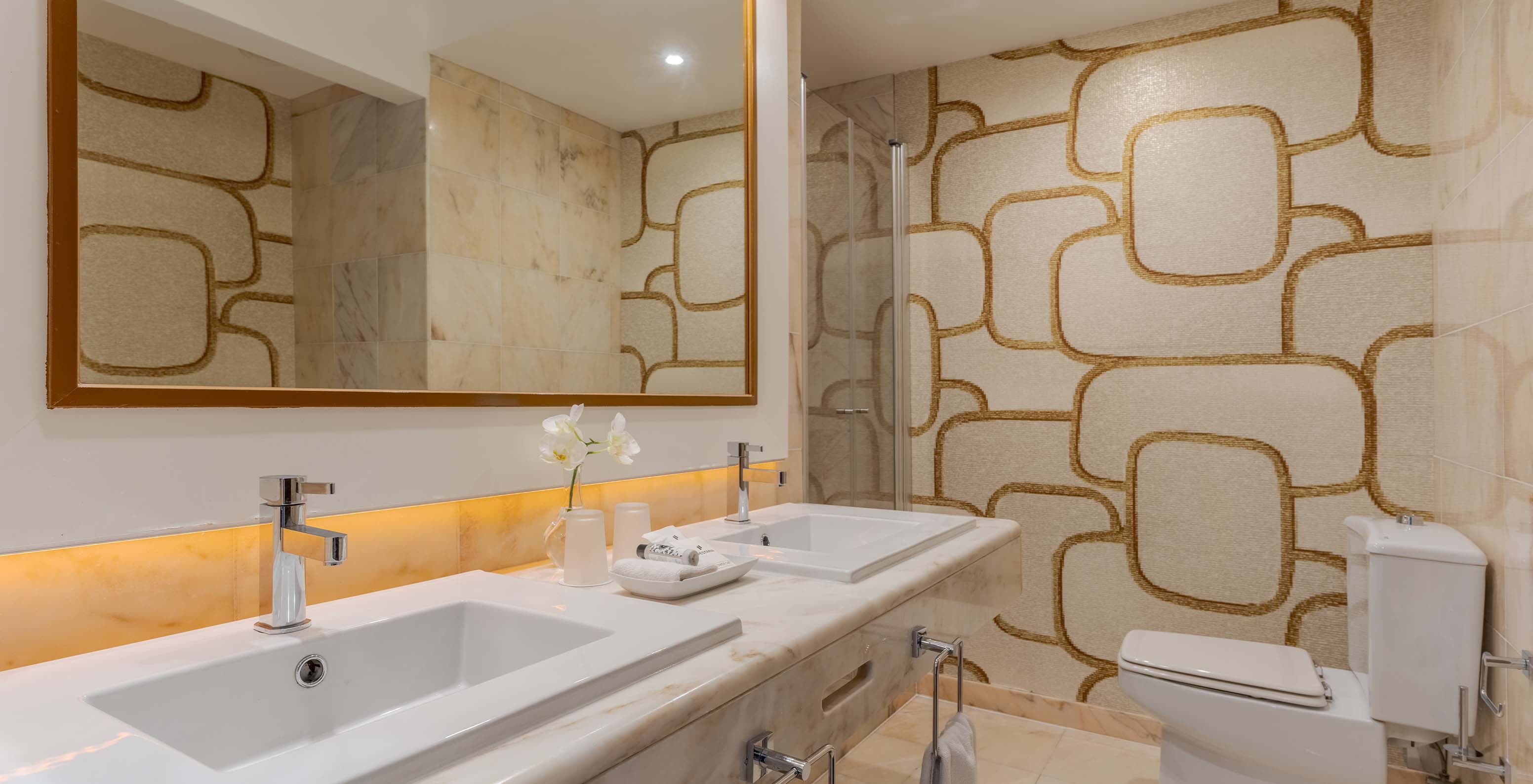 The Sea View Deluxe at Pestana Alvor Praia has a marble bathroom with two sinks, a large mirror, and toilet