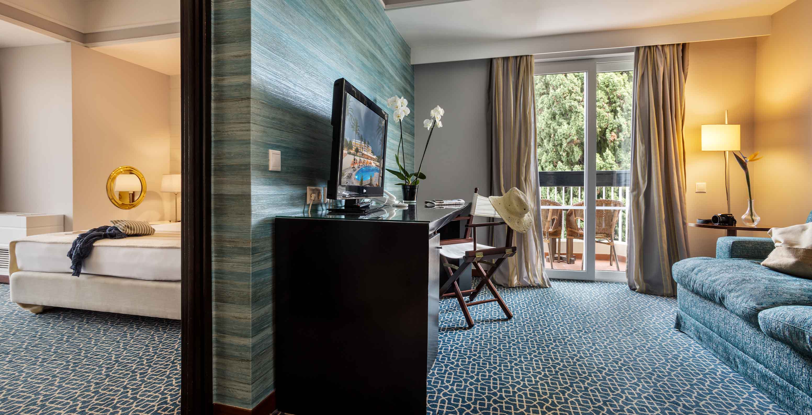 The Garden View Suite at Pestana Alvor Praia has a division between the living room with sofa and TV and bed