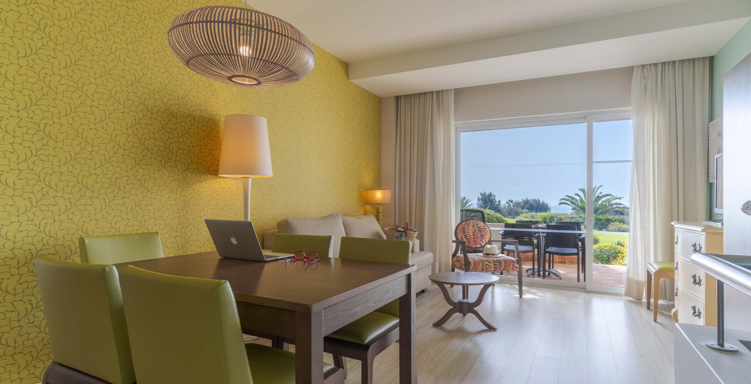 The Duplex Sea View Suite T1 at Pestana Alvor Praia has a living room with a dining table and a balcony
