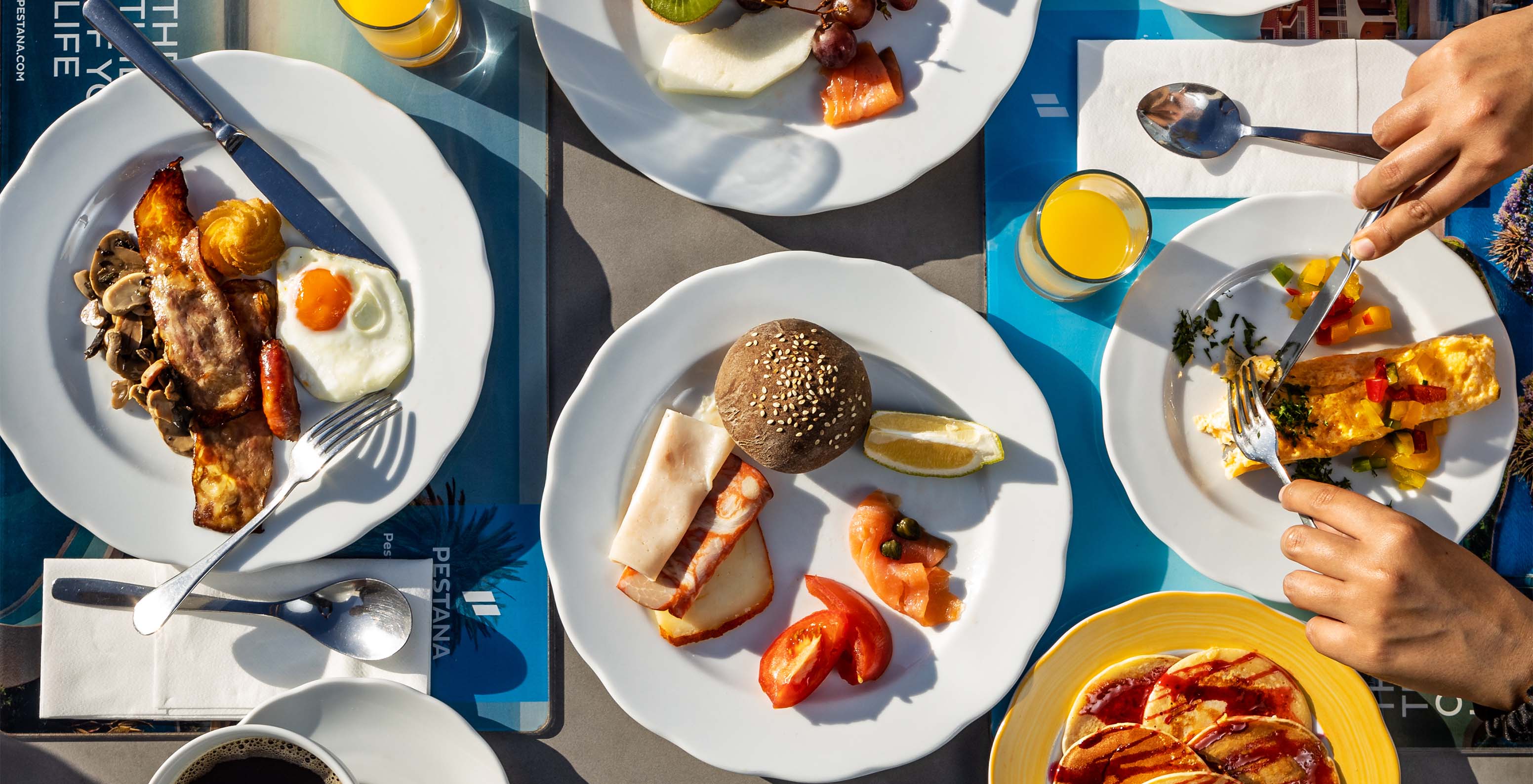 Breakfast with varied options like bread, eggs, and juices at Pestana Alvor Praia, Hotel with Spa and Pool
