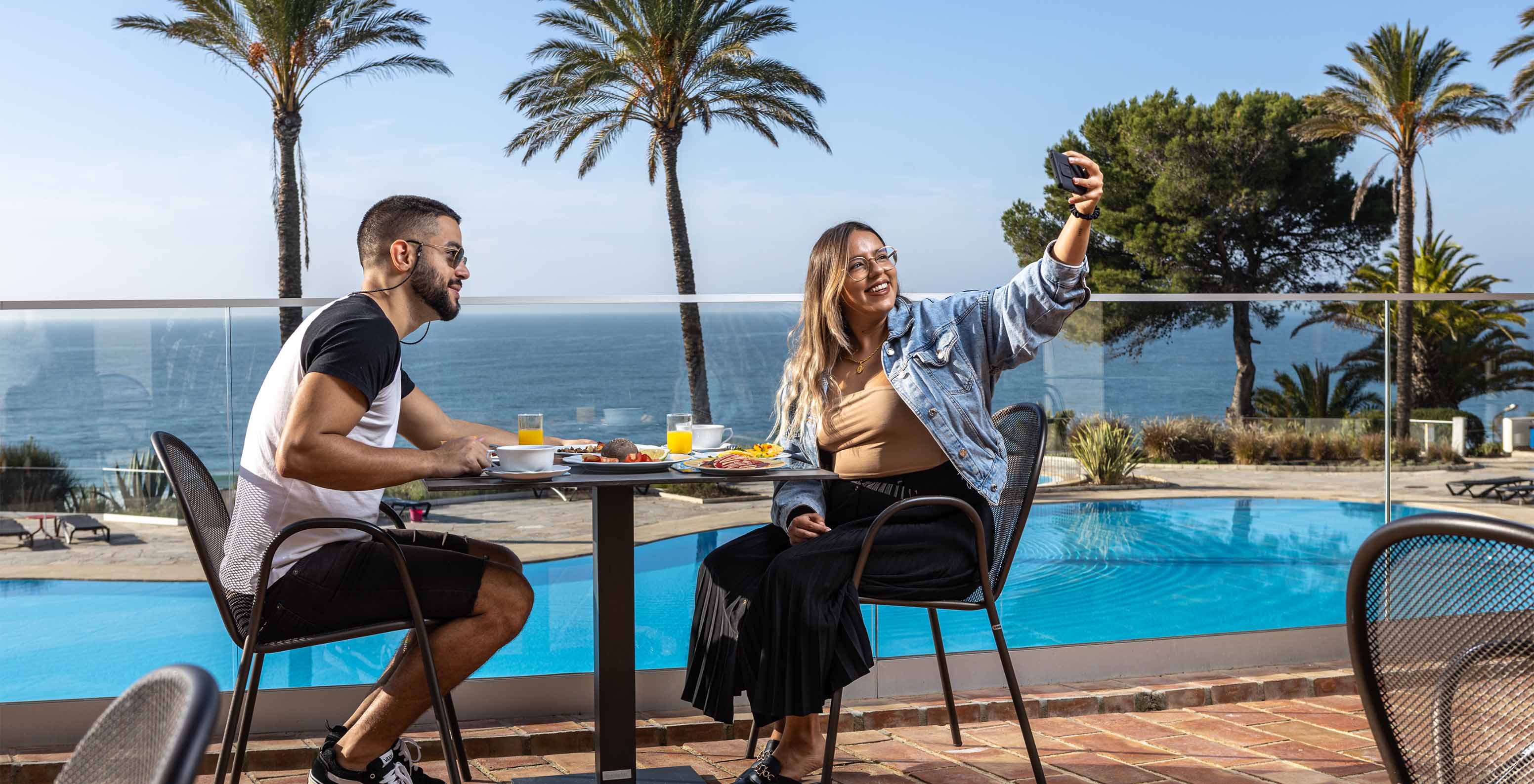 Couple taking a selfie while having breakfast on the terrace of the restaurant at Pestana Alvor Praia