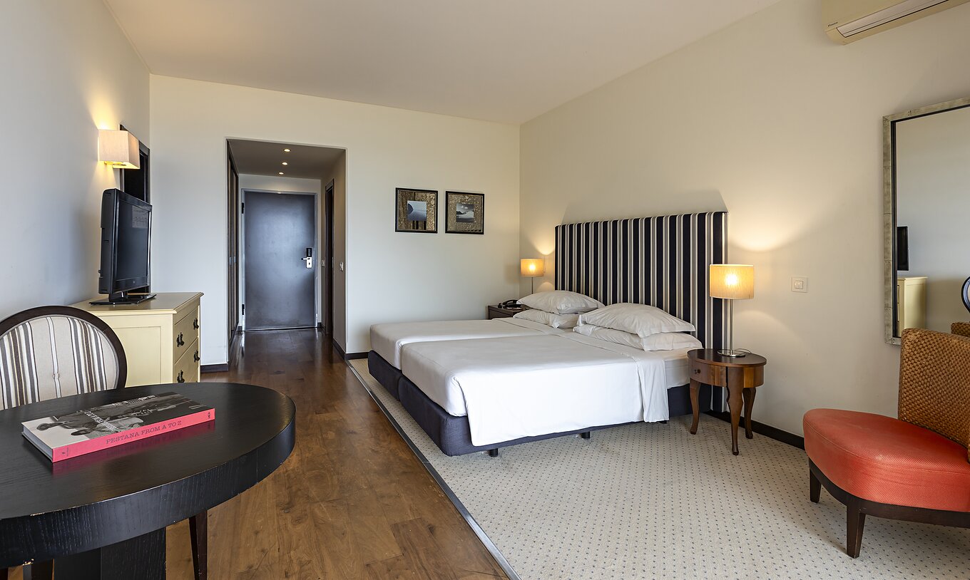 The Cliff Suite T1 at Pestana Alvor Praia has a double bed, with a television, a mirror, a table, and a chair
