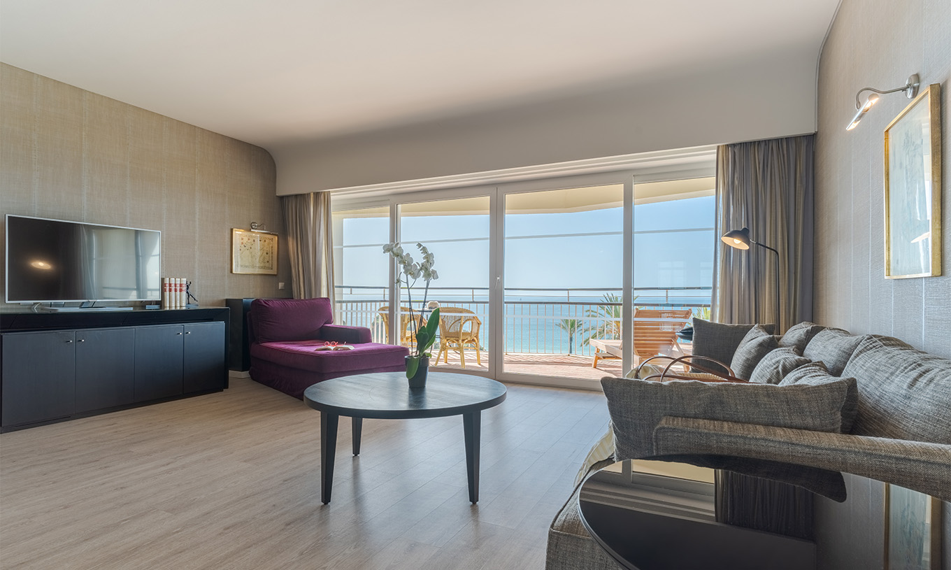 The Luxury Sea View Suite at Pestana Alvor Praia has a living room with a sofa, armchair, table, and sea views