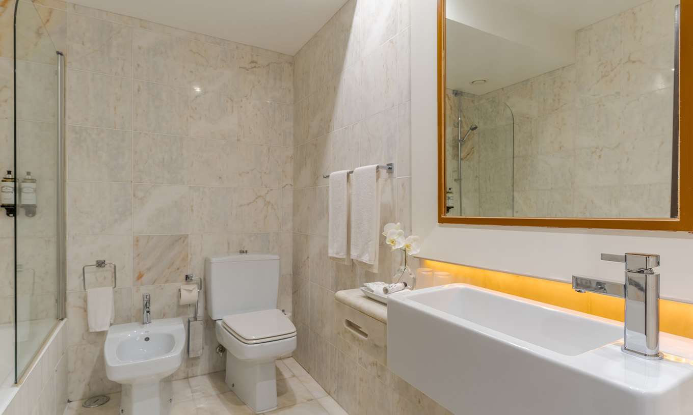 The Deluxe at Pestana Alvor Praia has a light marble bathroom with sink, mirror, toilet, bidet, and bathtub