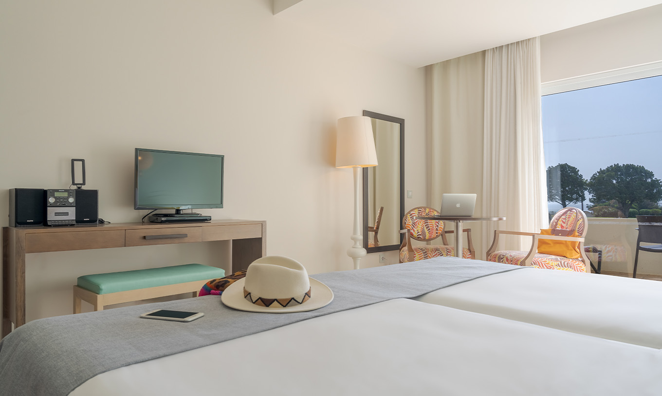 The Sea View Studio at Pestana Alvor Praia has a desk with a TV, a wall mirror, and a window to the balcony
