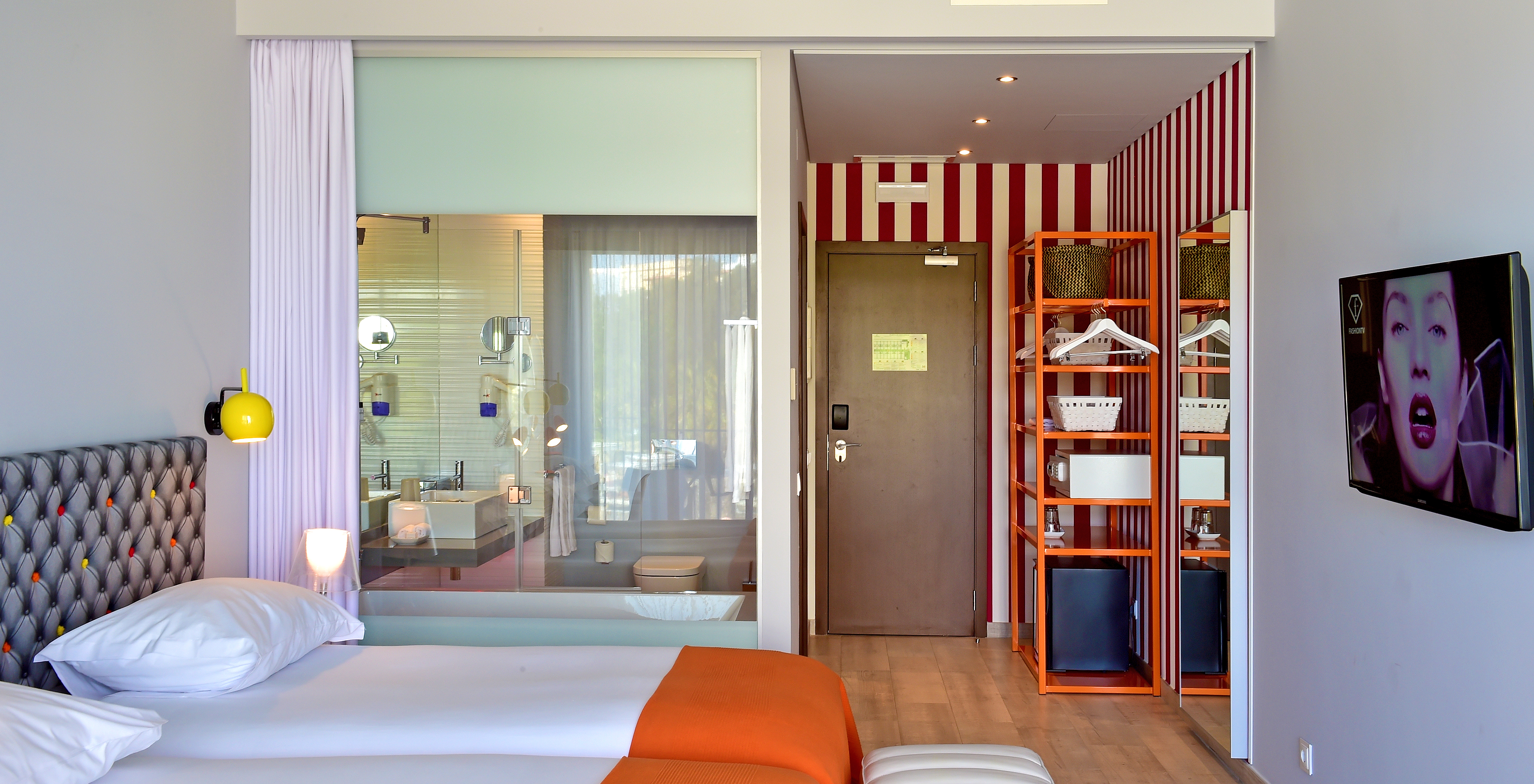 The Deluxe Pool View of Pestana Alvor South Beach has a bathroom with bathtub and window to the room