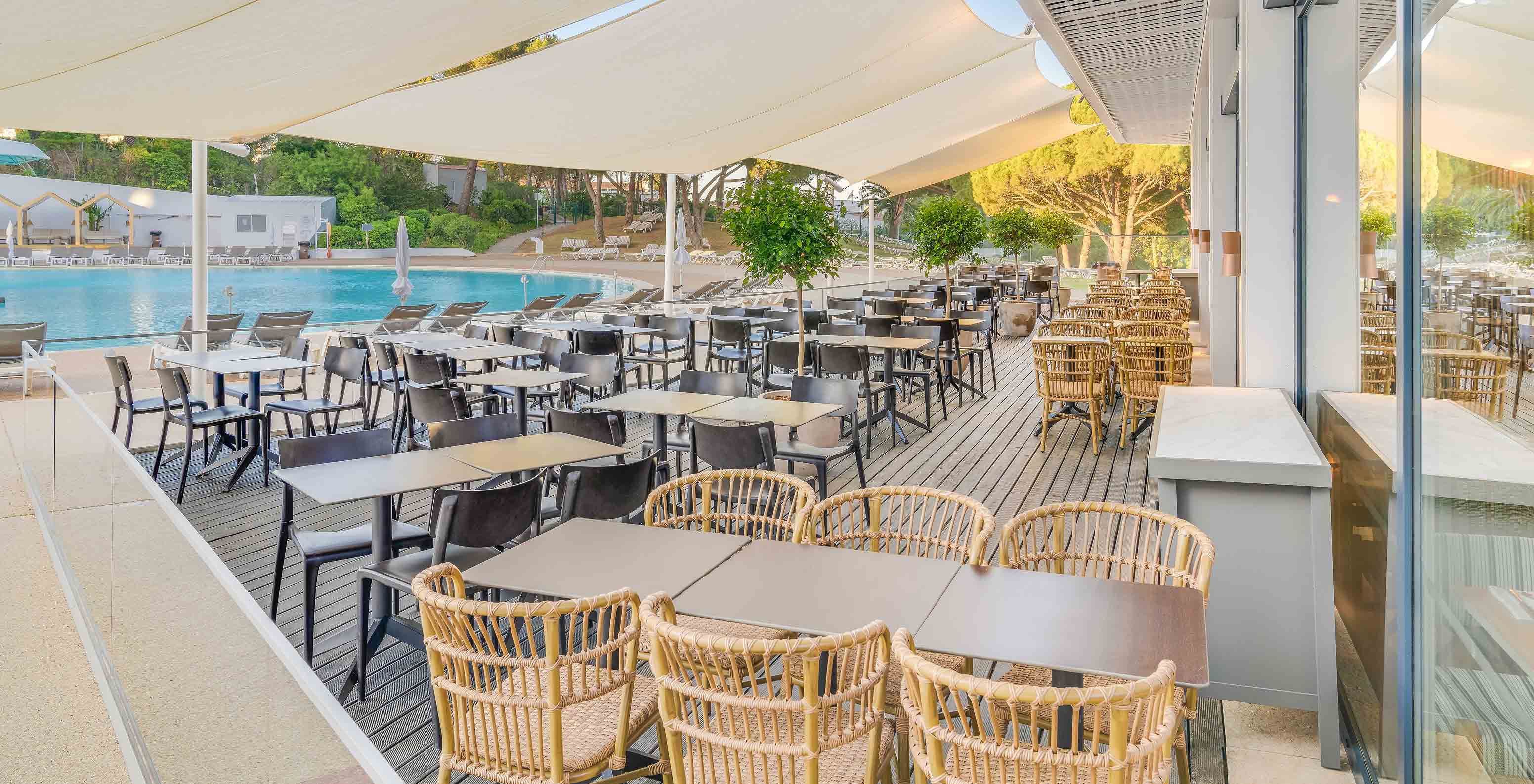 The Acqua Bar, at the All-Inclusive Hotel in the Algarve, has tables and chairs outside by the pool.