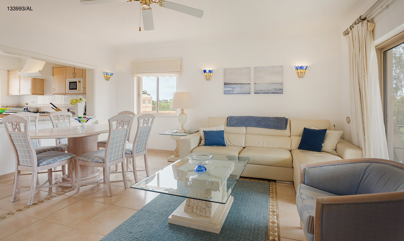 The Pestana Carvoeiro Golf T2 Superior Apartment has a living room with a white sofa, dining table, and six chairs
