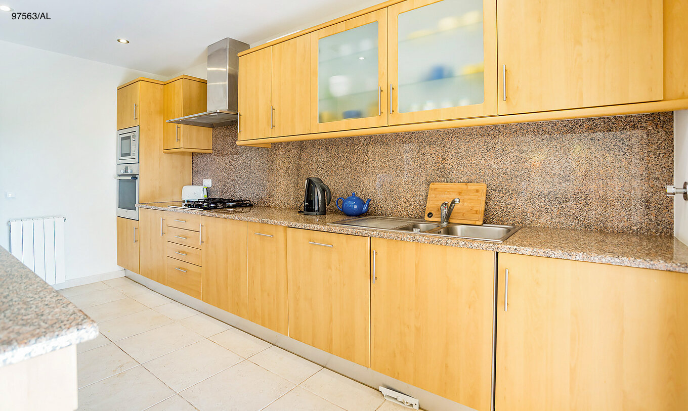 The Pestana Carvoeiro Golf T3 Superior Apartment has a kitchen with wooden cabinets and appliances