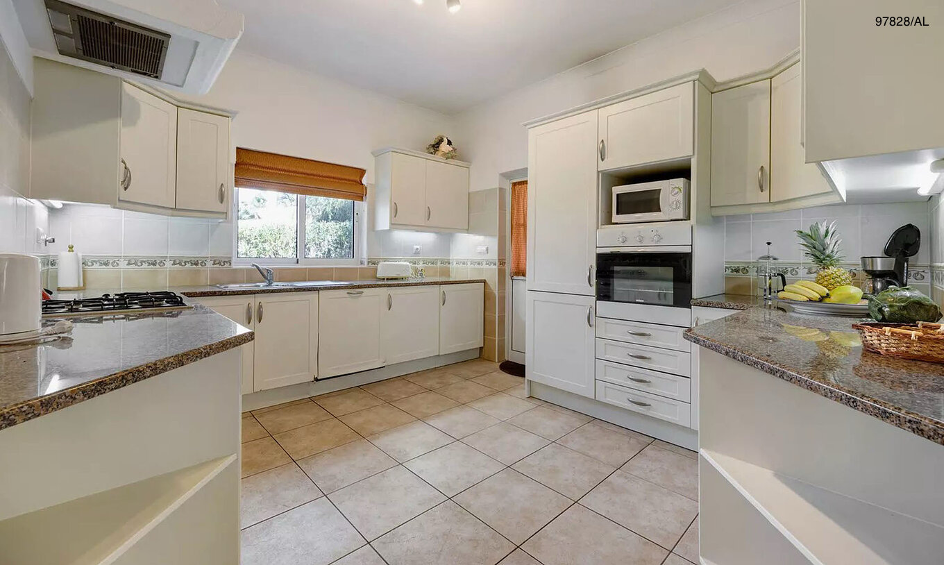 The Pestana Carvoeiro Golf V3 Standard Villa has a kitchen equipped with white cabinets and appliances