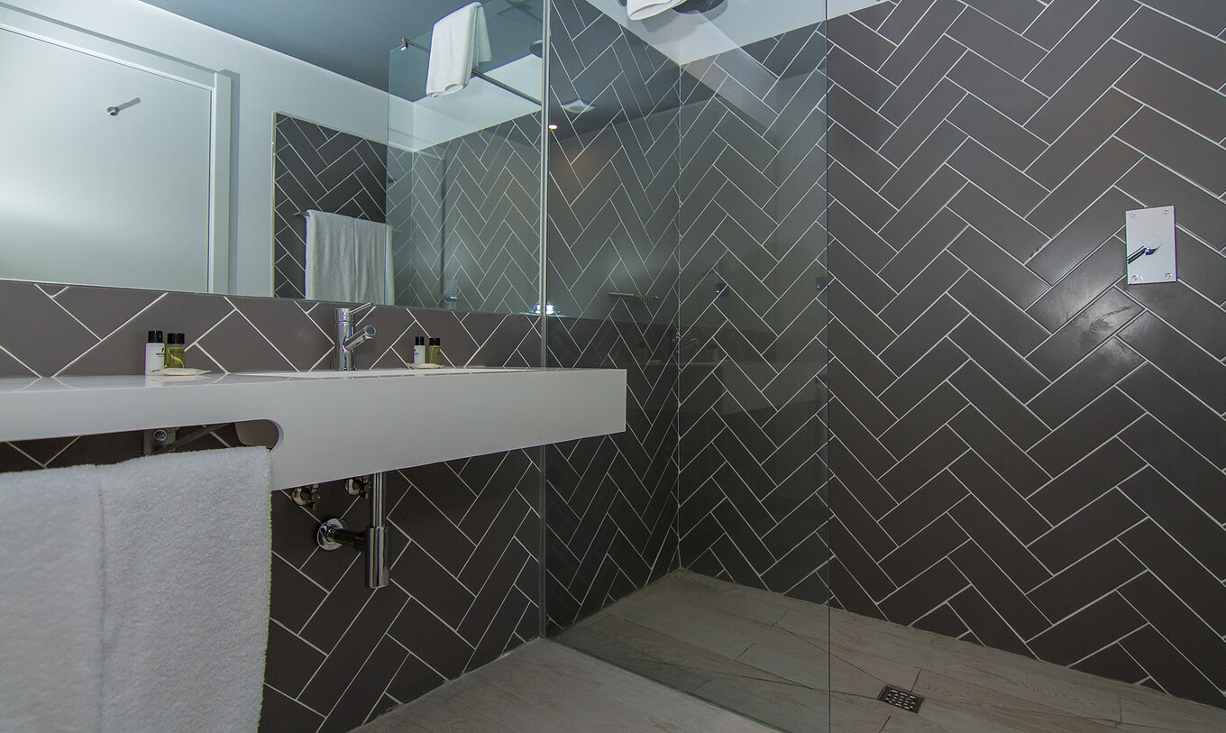 The Classic room at Pestana Gramacho Residences features a bathroom with a walk-in shower, sink, and mirror