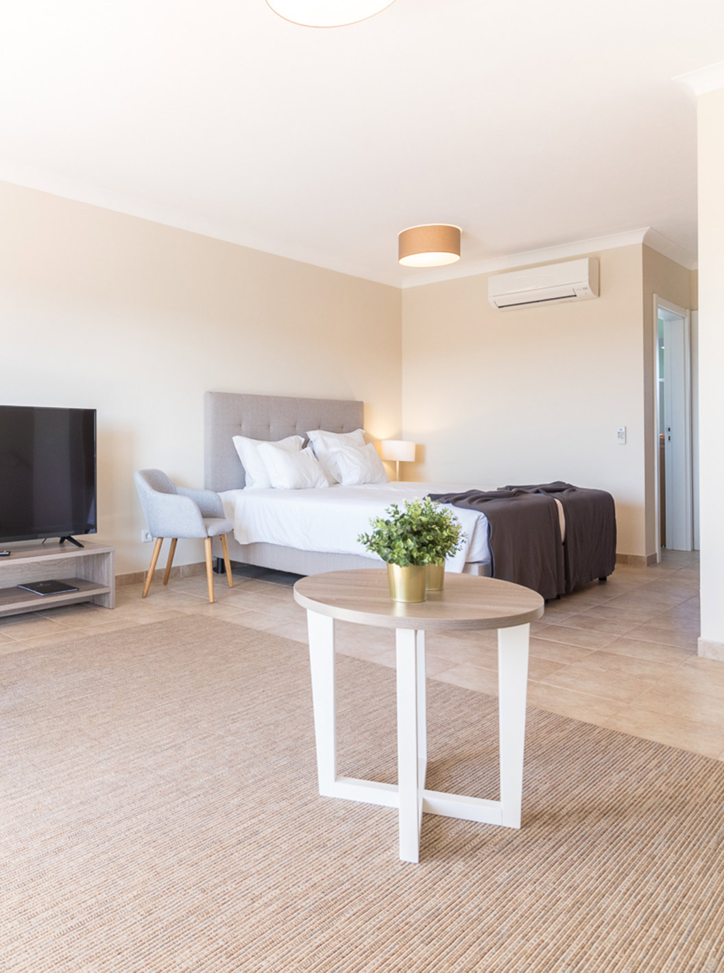 The studio at Pestana Gramacho Residences is modern with bed, TV, dining table and minimalist decor