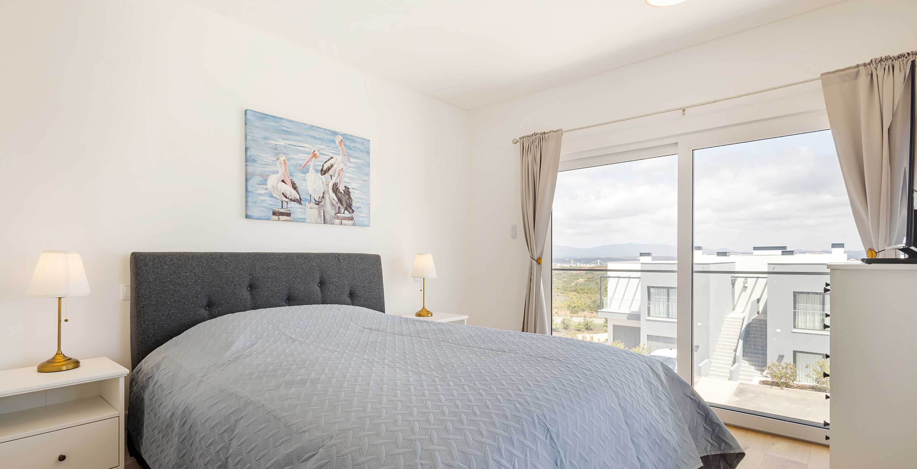 Pestana Valley Nature Village apartment with a bed and grey-toned curtains