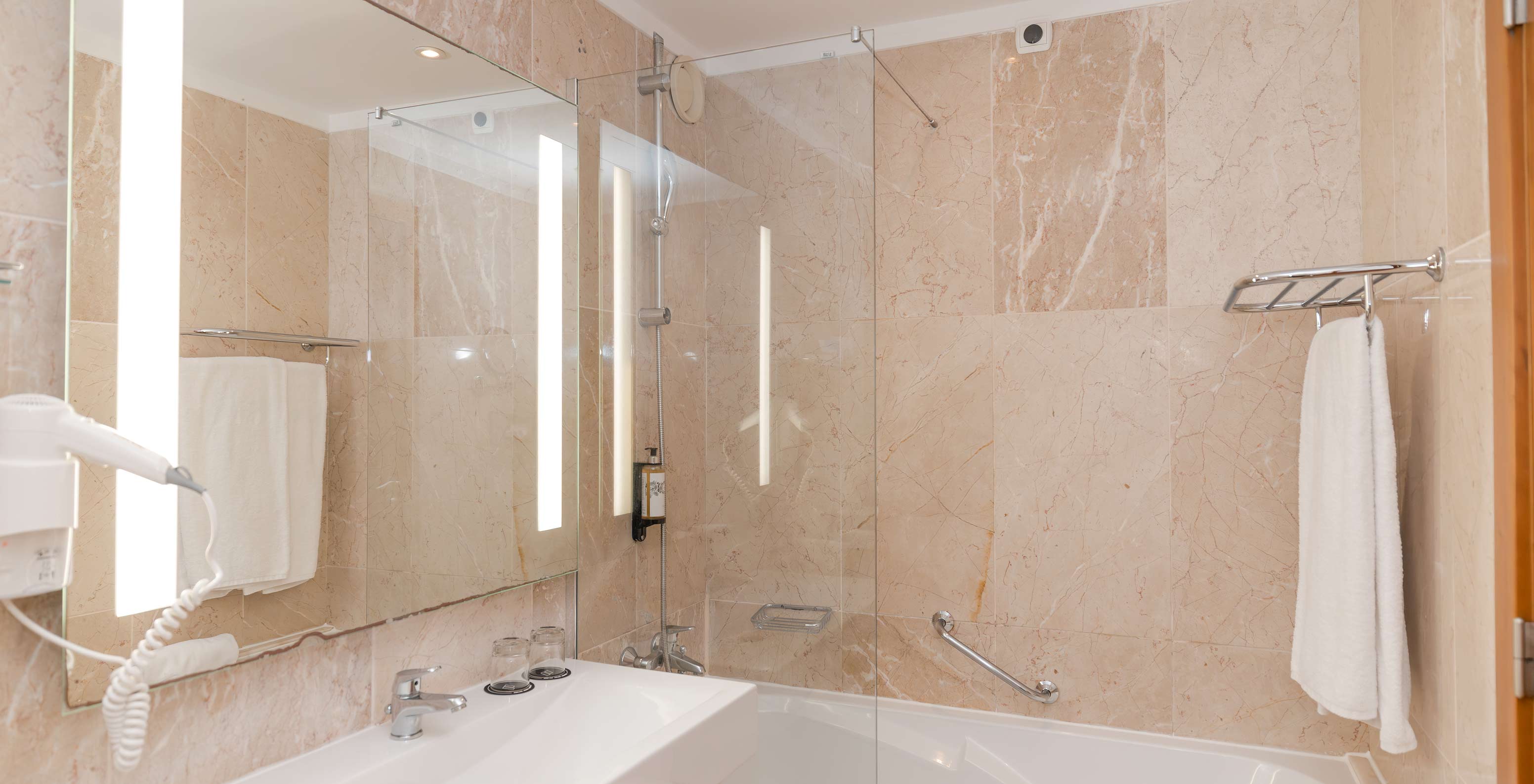 The Sea View Suite at Pestana Viking features a bathroom with sink, mirror, and bathtub with shower