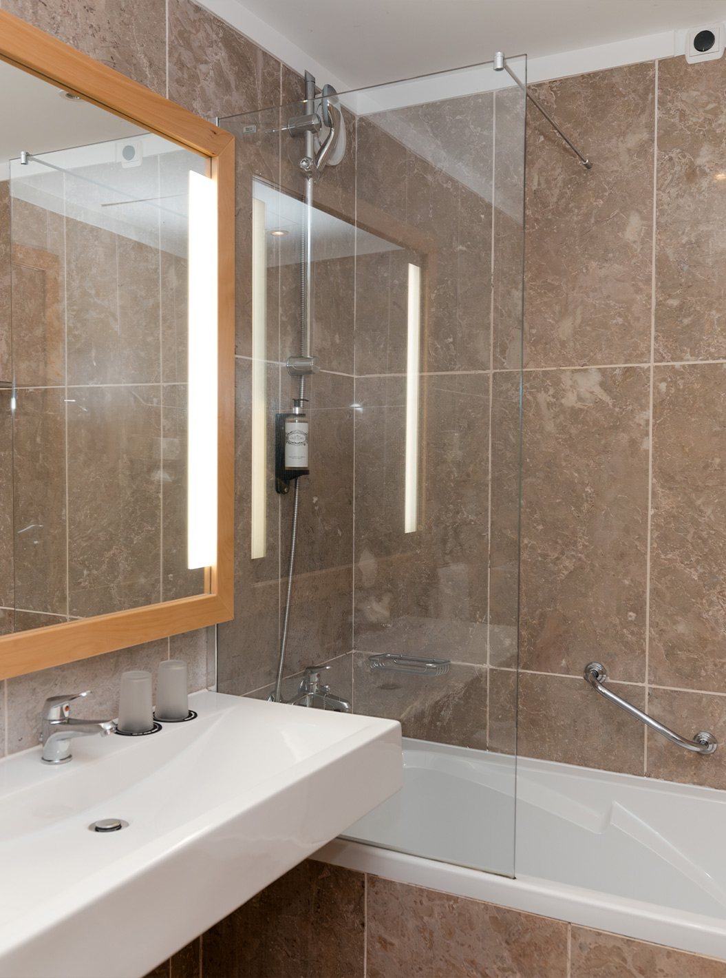 The Deluxe Sea View at Pestana Viking has a bathroom with sink, large mirror and bathtub with shower