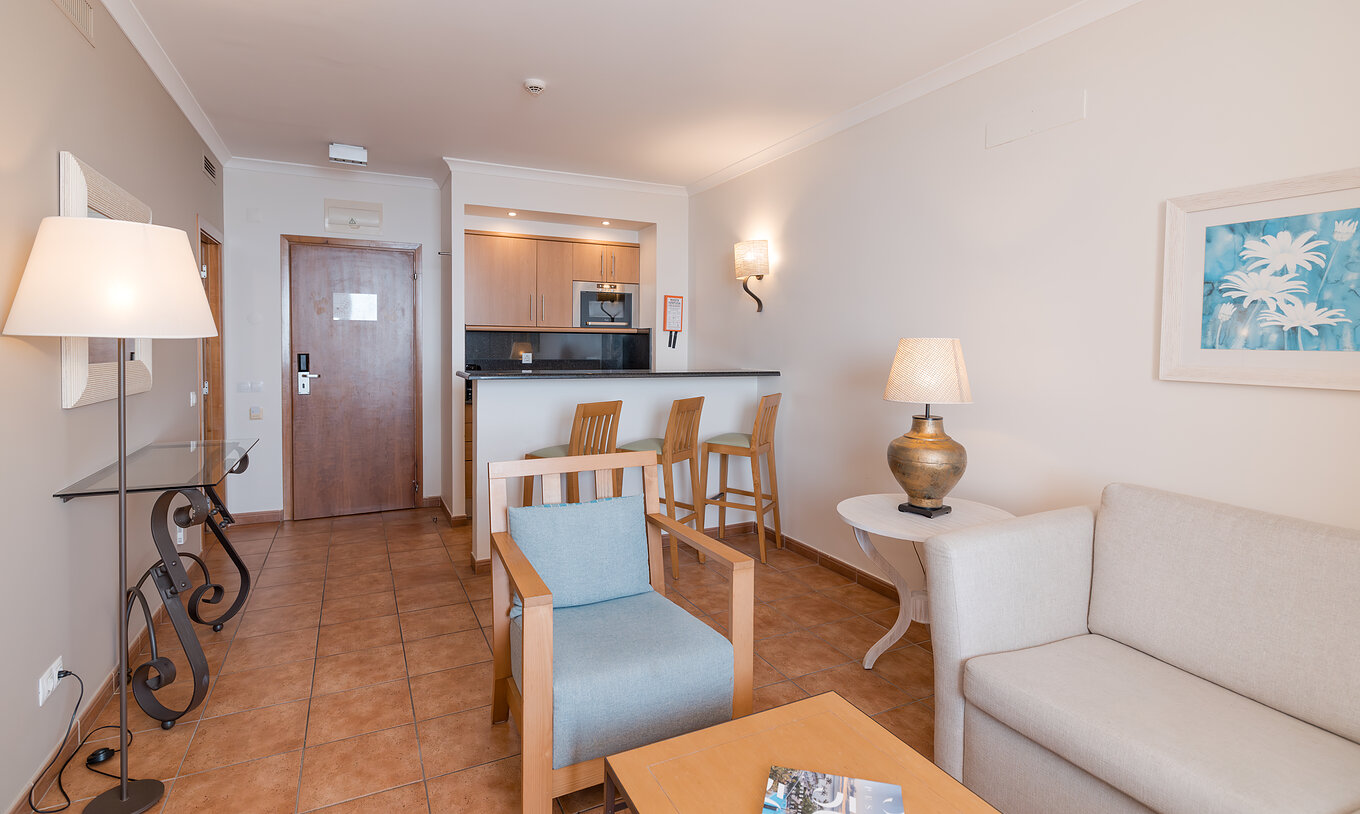 The Superior Sea View Suite at Pestana Viking has a living room with sofa, armchairs and kitchen with microwave