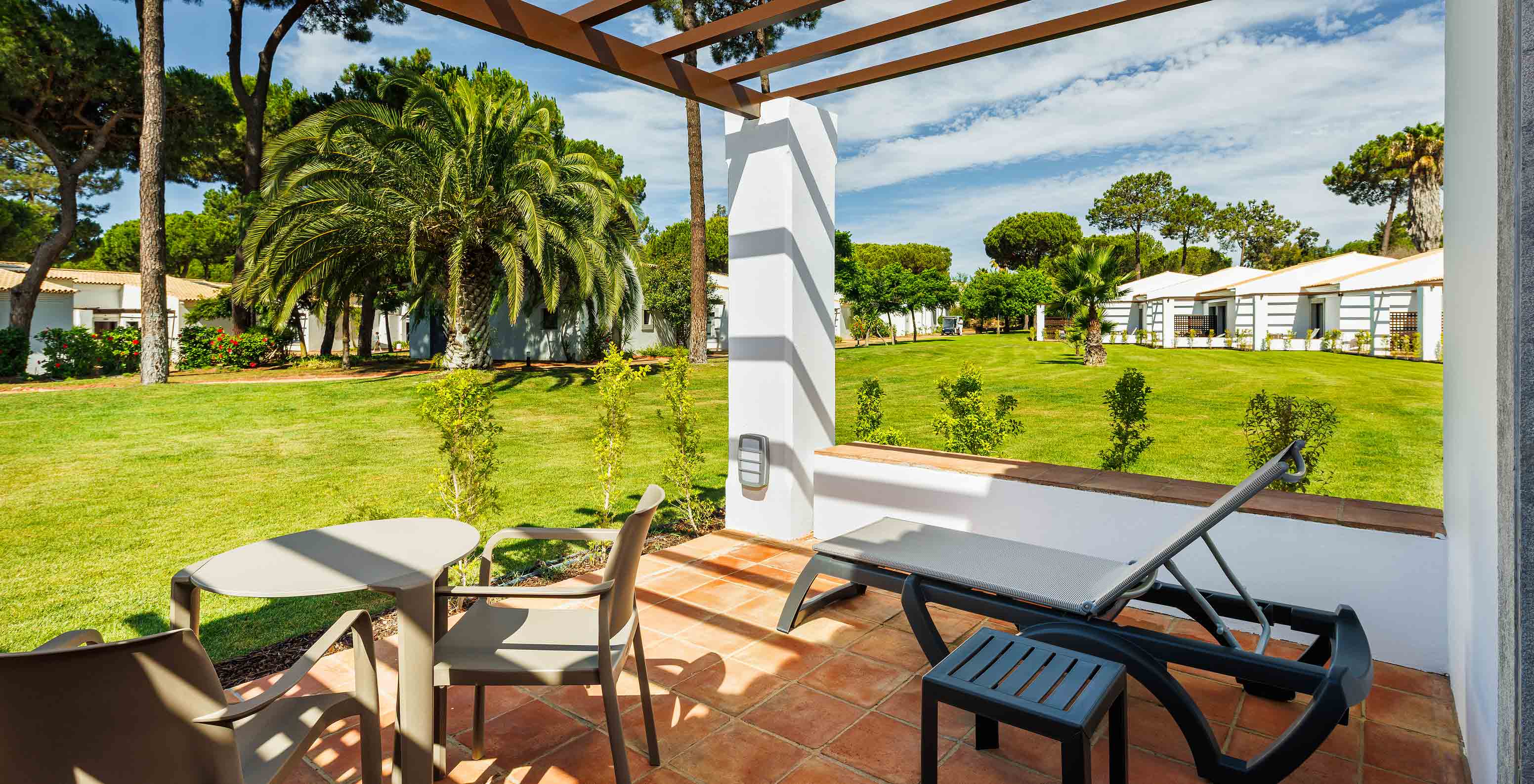 The Family Garden View at Pestana Vila Sol - Vilamoura has a balcony with sun lounger, table and garden view