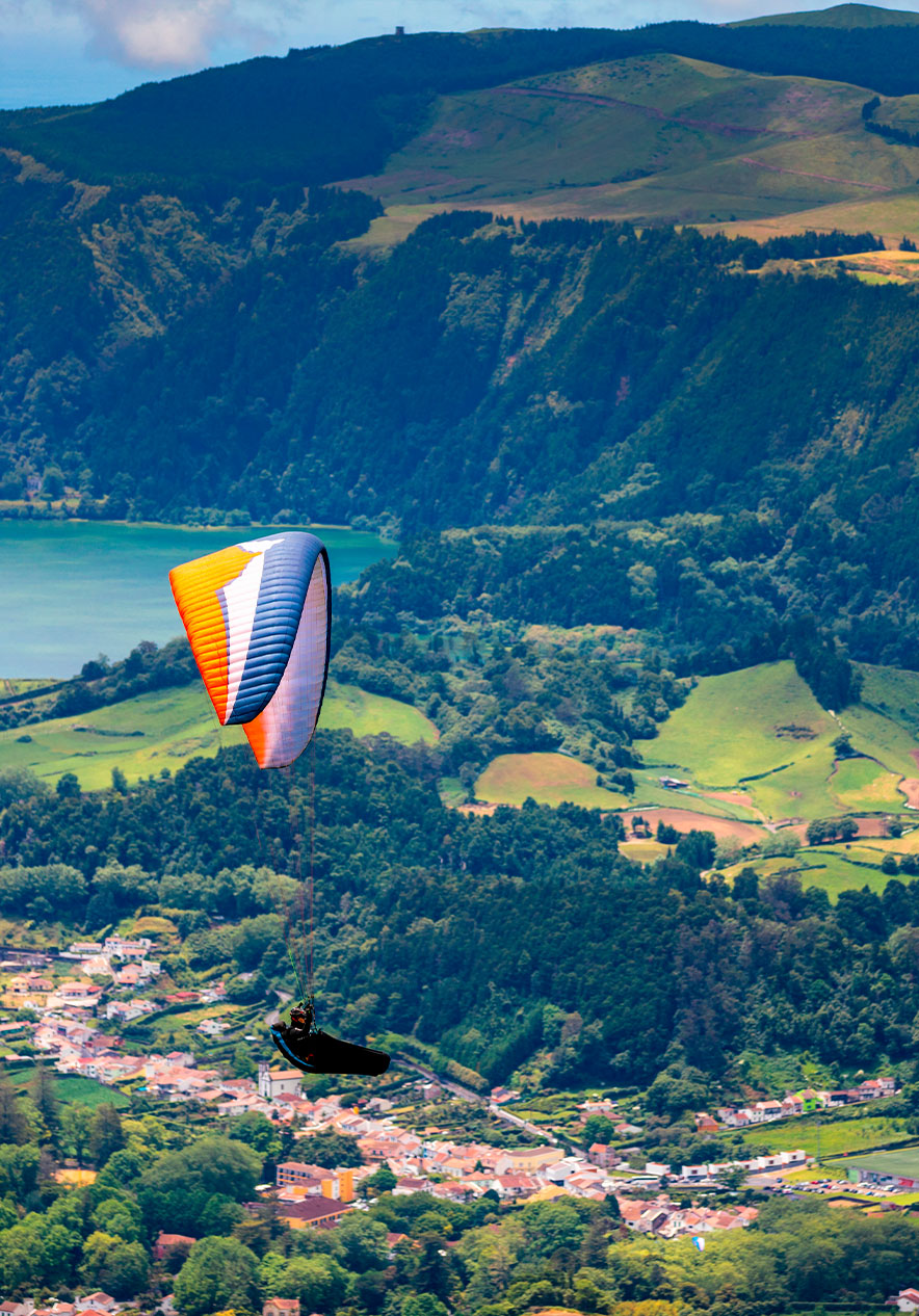 Paragliding over green valleys near Pestana Bahia Praia, Hotel 4 Estrelas nos Açores with lake views