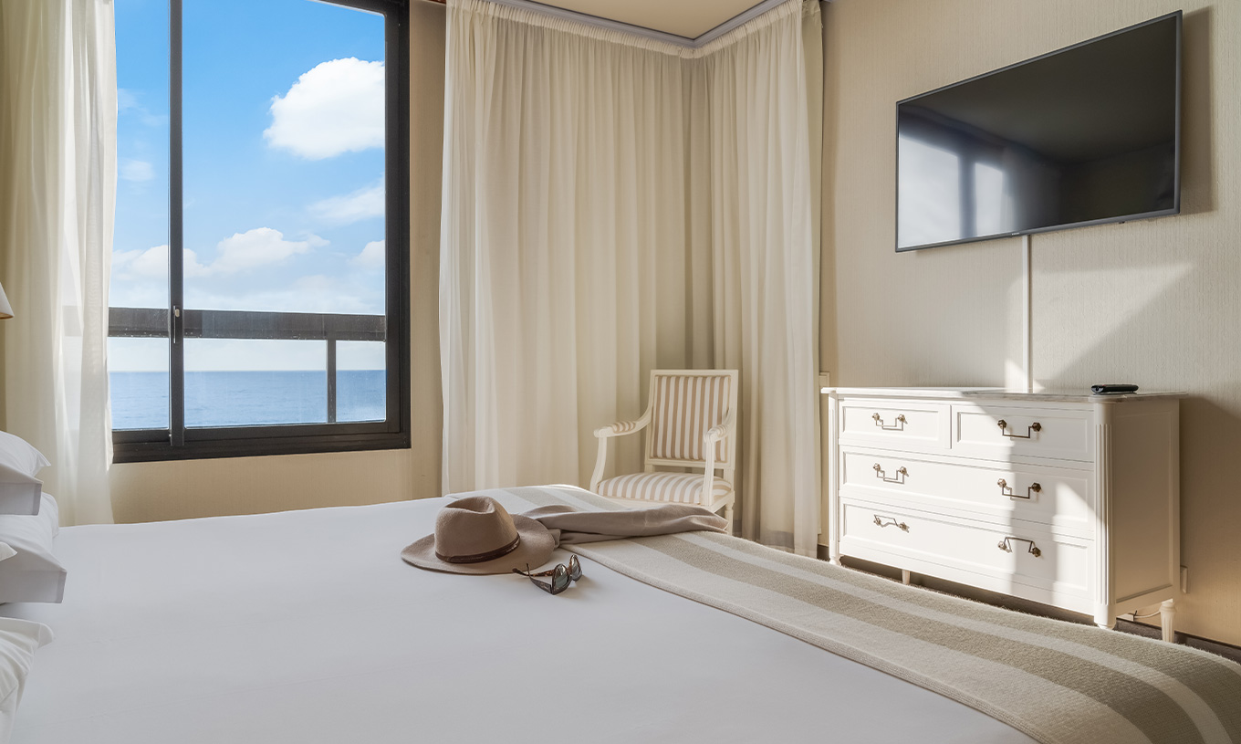 Suite at Pestana Bahia Praia has a double bed, with a window on the left and a TV at the foot of the bed