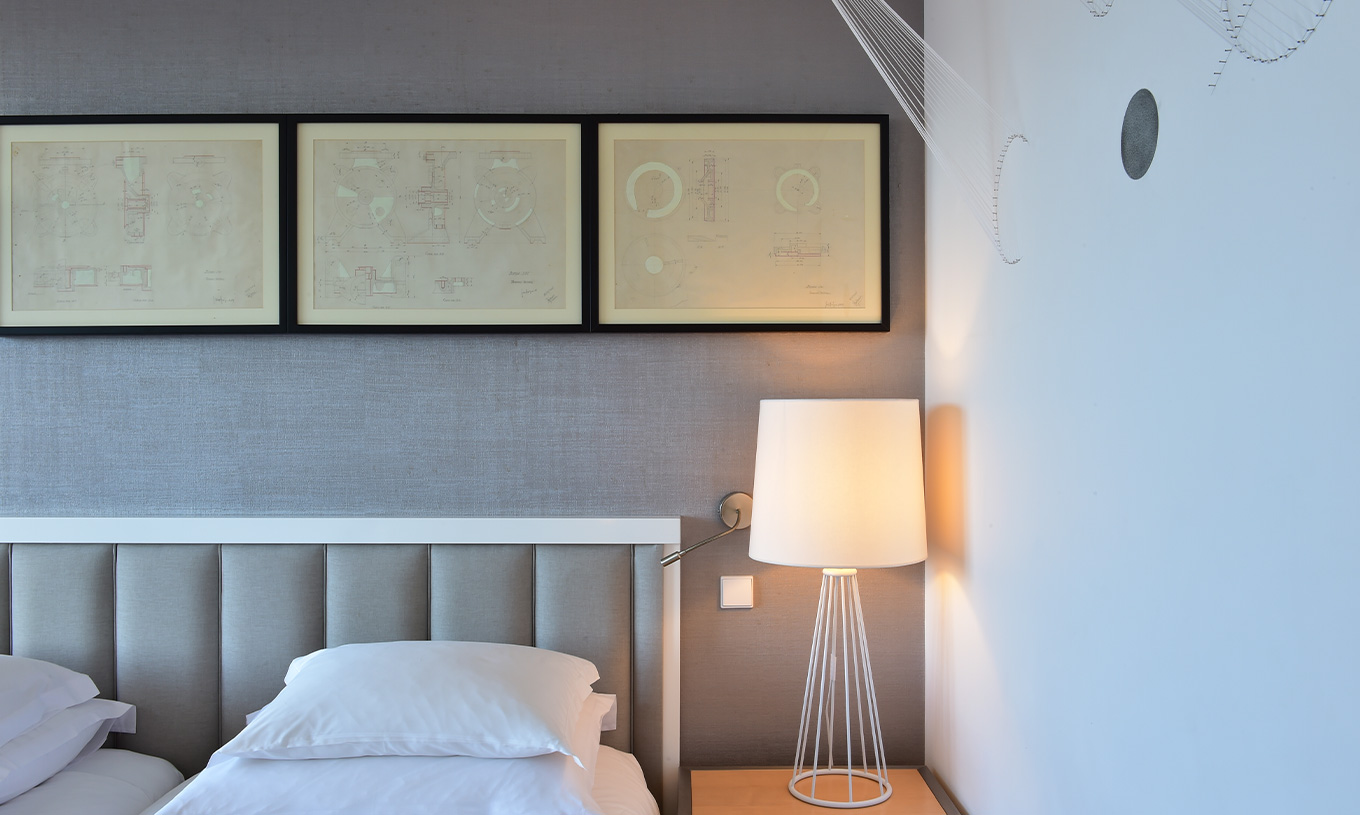 The Double Room Art District at Pestana Cidadela Cascais features an art wall, bedside table with a lamp, and paintings