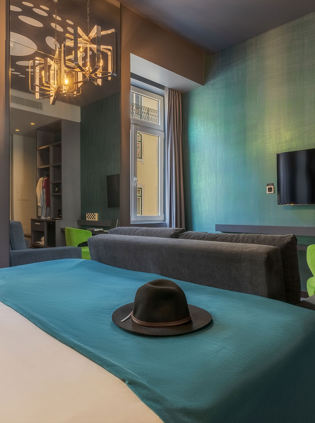 The CR7 Family Hat-Trick Room at Pestana CR7 Lisboa has a mirror, a sofa with television, and a bed
