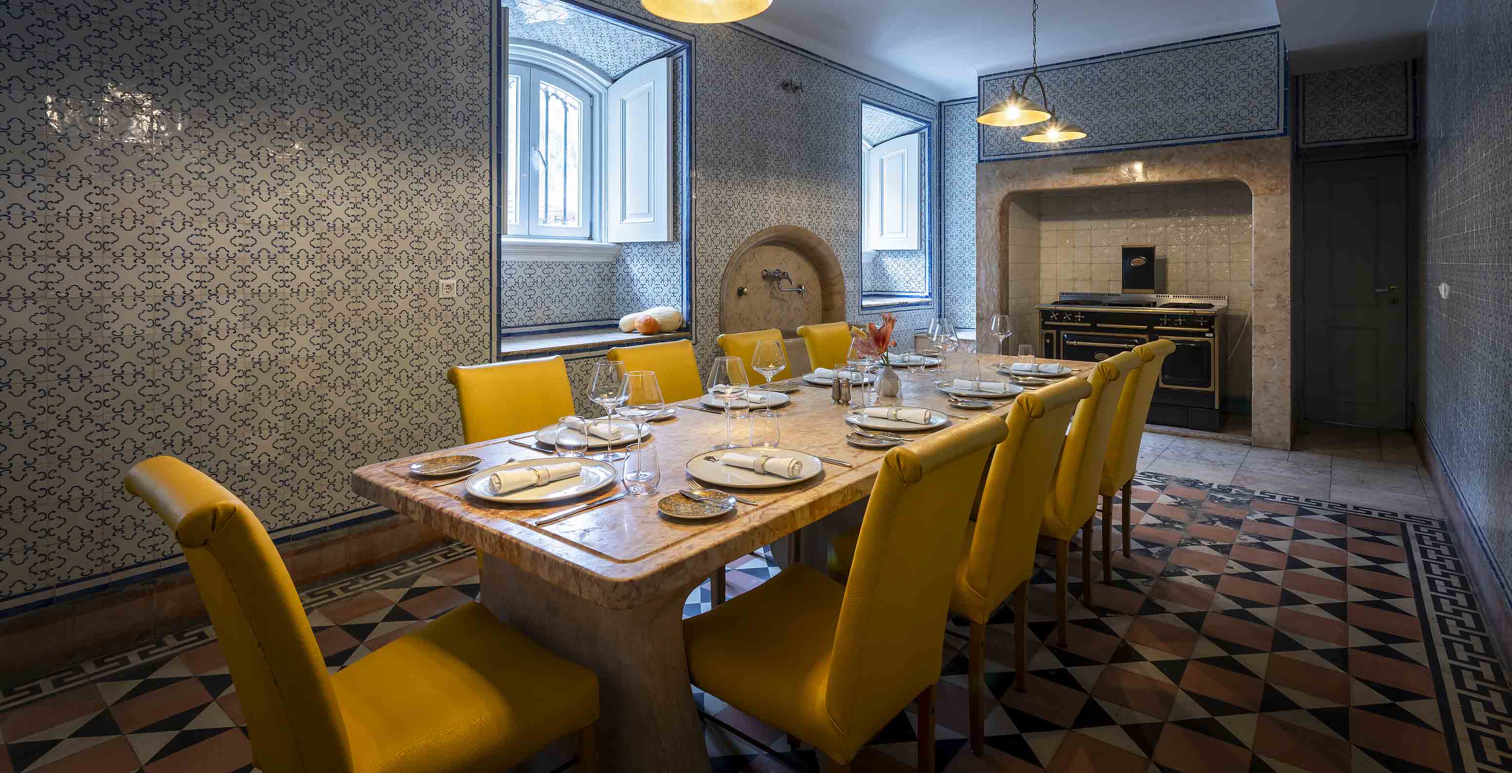 Pestana Palace Lisboa has an old kitchen for private events, with a stone table and yellow chairs