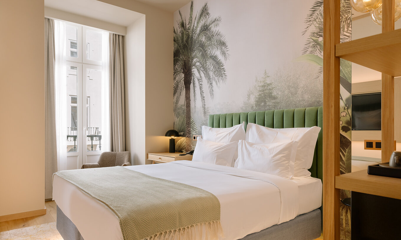 The Classic Room of Pestana Rua Augusta Lisboa has a double bed and window with curtains and view of downtown Lisbon