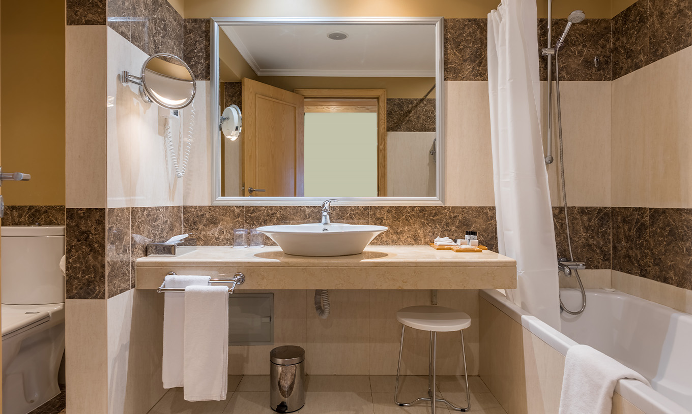 The Twin Classic Room with City View at Pestana Carlton Madeira has a tiled bathroom, bathtub, and toilet