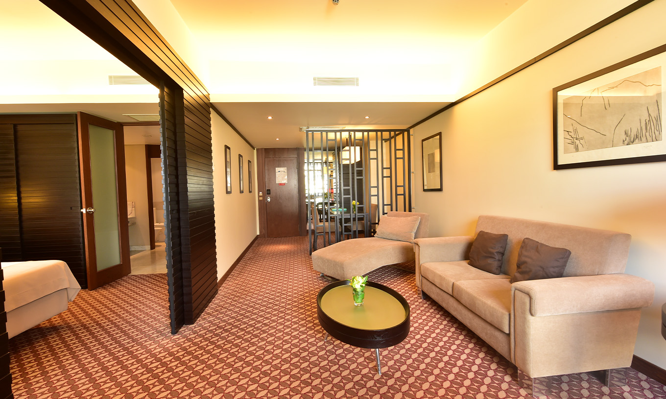 The Classic Land View room at Pestana Casino Park has a seating area with a sofa, chaise longue, and side table