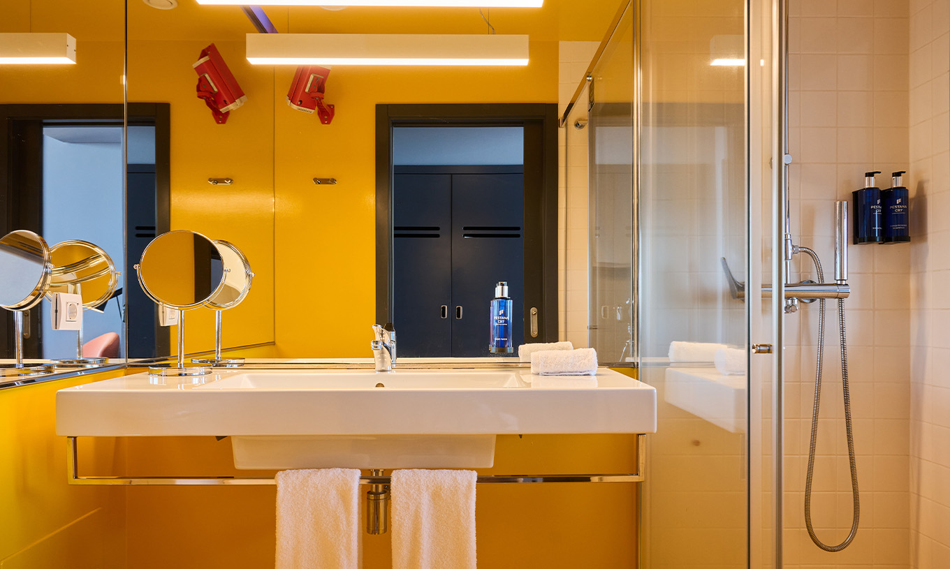 The CR Superior Room at Pestana CR7 Funchal has a modern yellow bathroom equipped with a shower