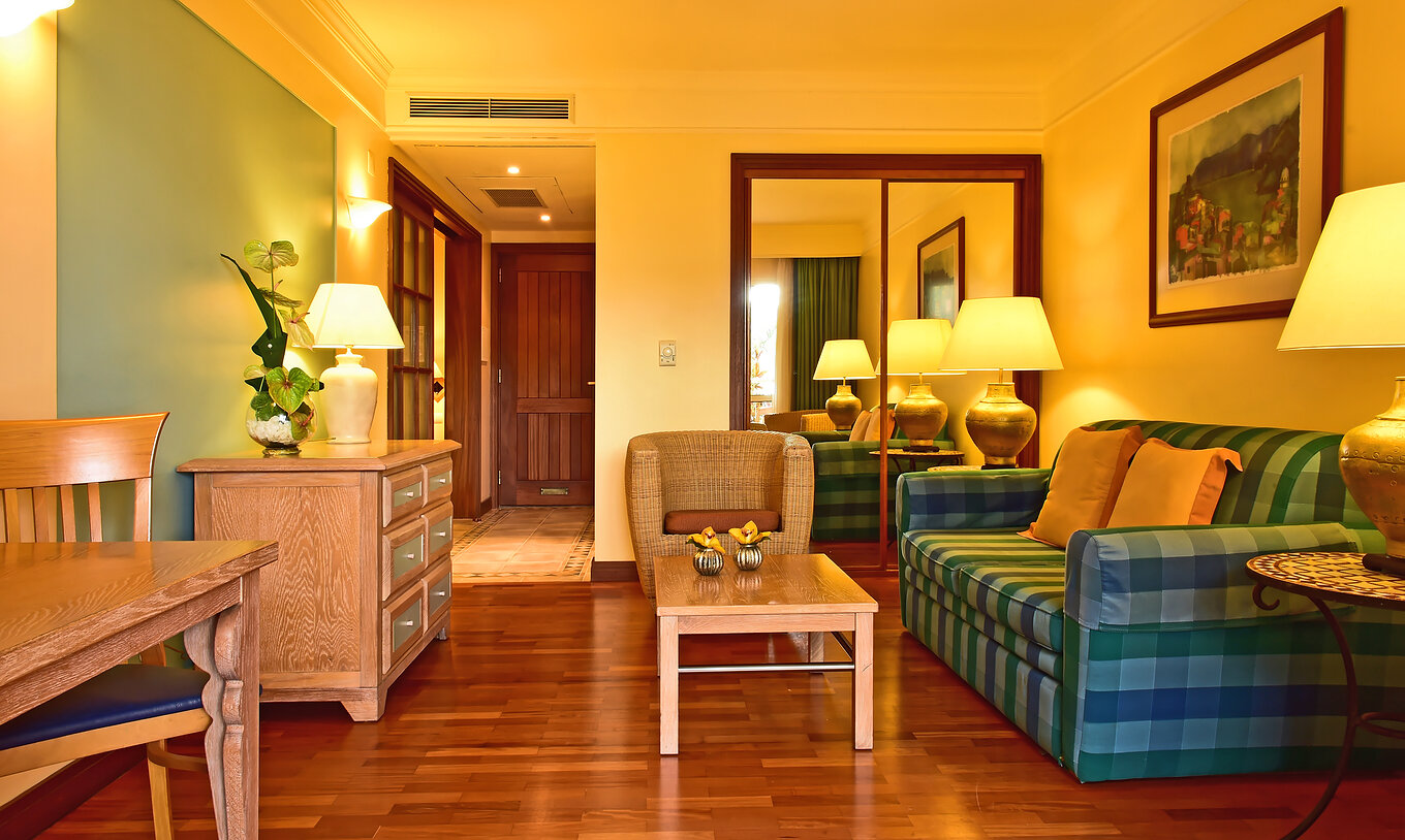 The Family Superior Room at Pestana Miramar has a living room with a sofa, an armchair, a table and a chest