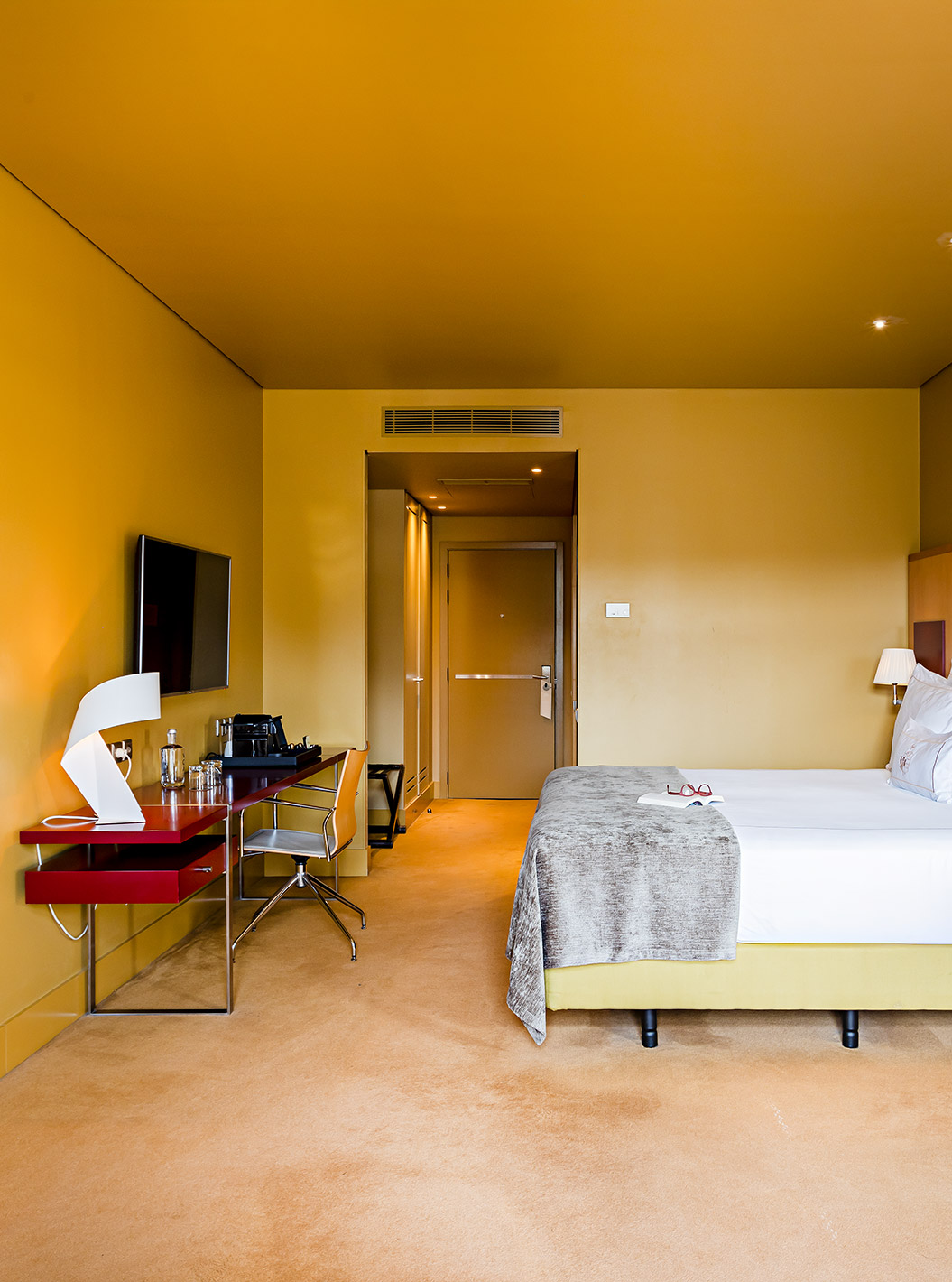 Pestana Palácio do Freixo’s Superior room has a double bed with grey cover and a desk