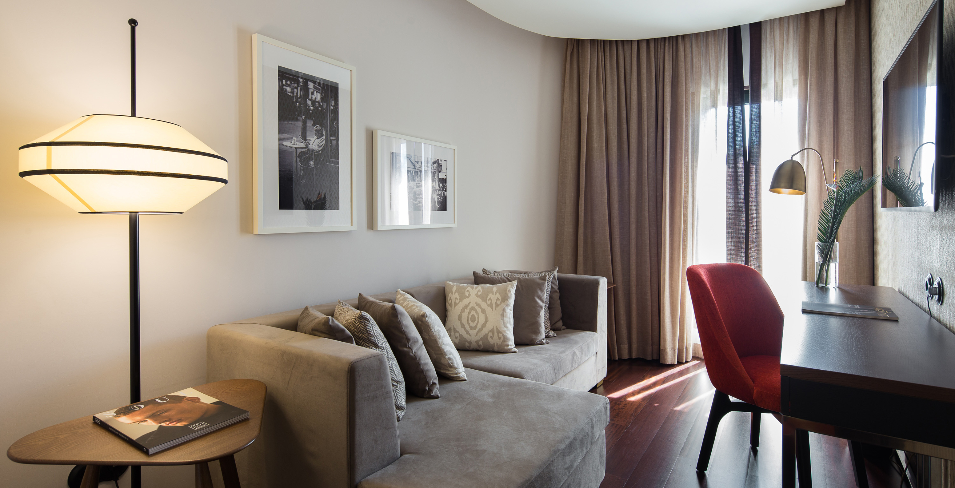 The Deluxe Executive do Pestana Porto - A Brasileira has a small room with sofa and a desk, and a window