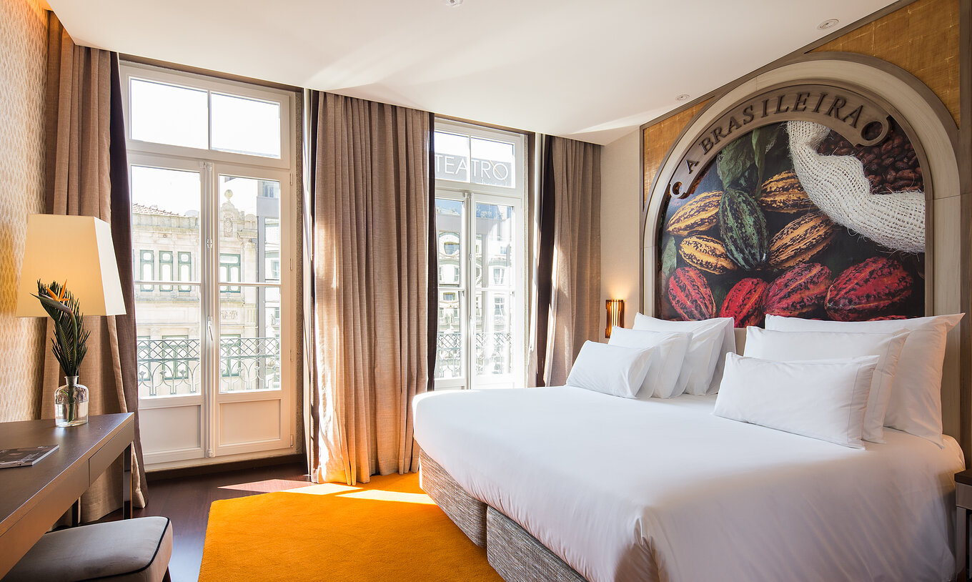 Deluxe Superior at Pestana Porto - A Brasileira with king bed, cocoa mural and tall balcony windows