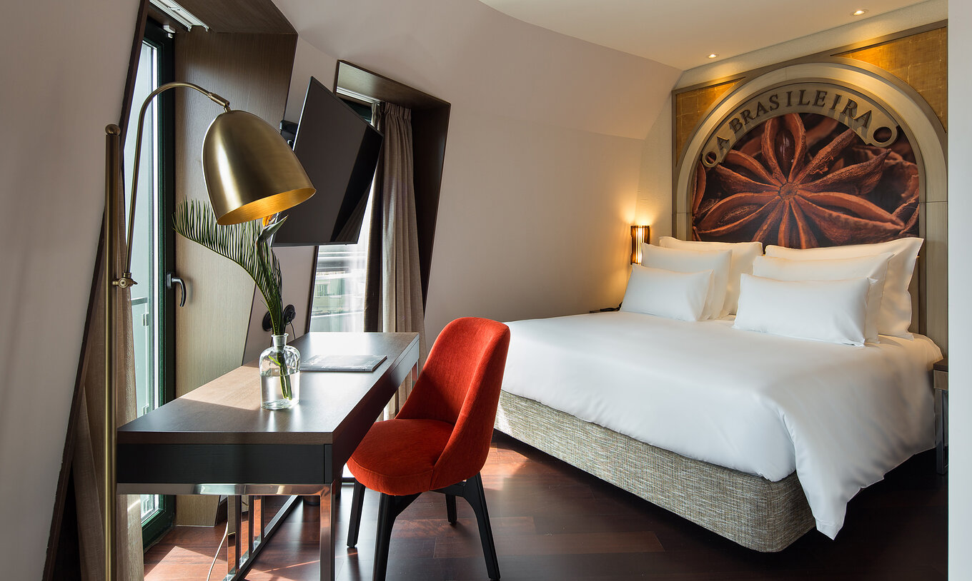 Premium Origin Room at Pestana Porto - A Brasileira featuring a desk, red chair and double bed with mural