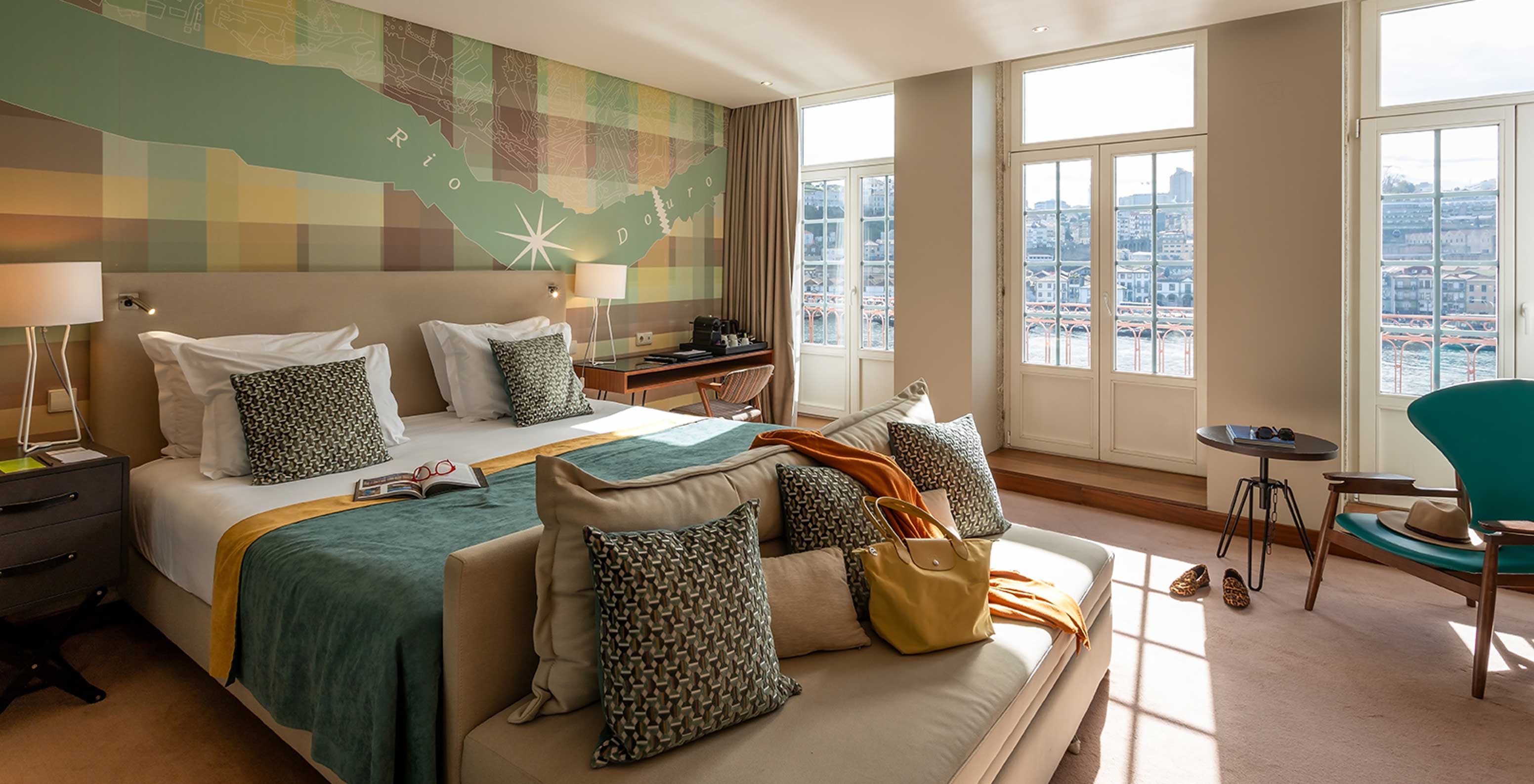 The Vintage Grand View Balcony at Pestana Vintage Porto has a double bed and windows with a view of the Porto riverside