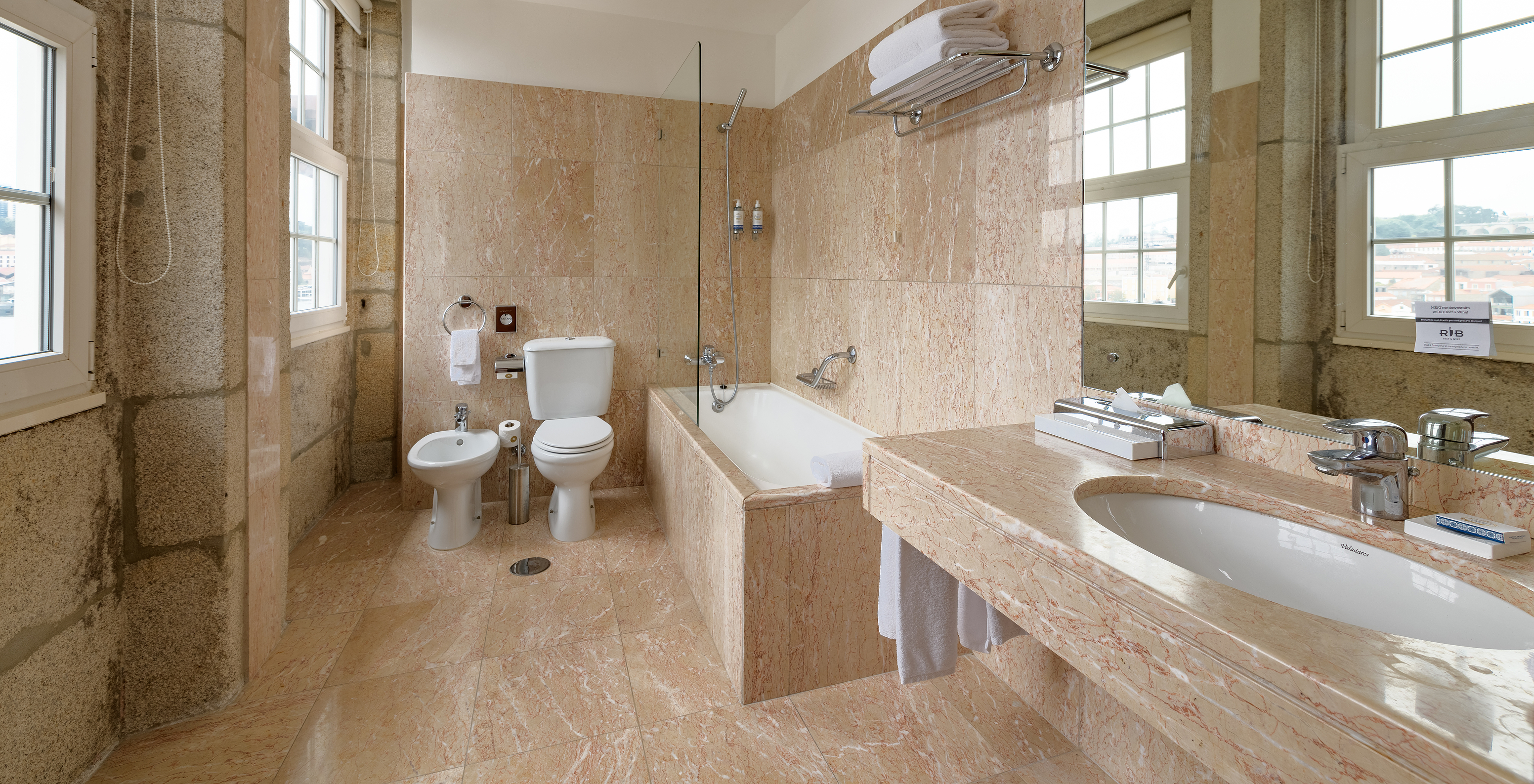 The Vintage Grand View room at Pestana Vintage Porto has a spacious bathroom with bathtub, toilet, sink and bidet