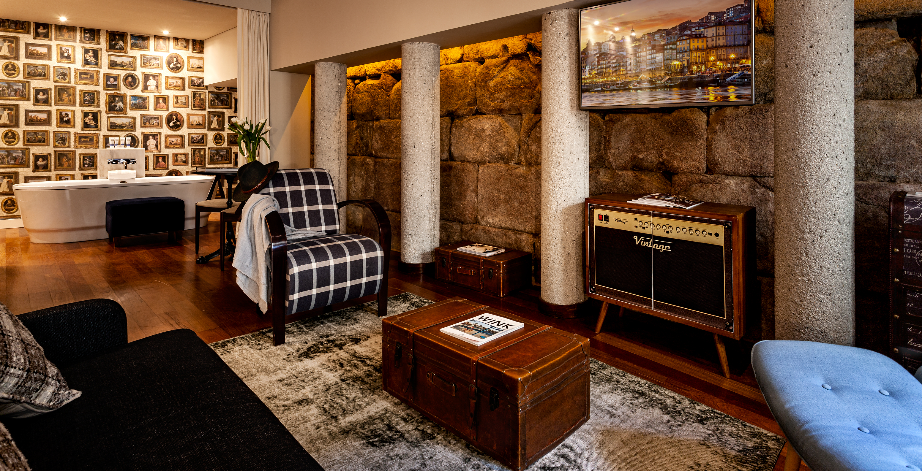 The Heritage Suite at Pestana Vintage Porto has a bathtub in the middle of the room, a seating area with a radio and sofas