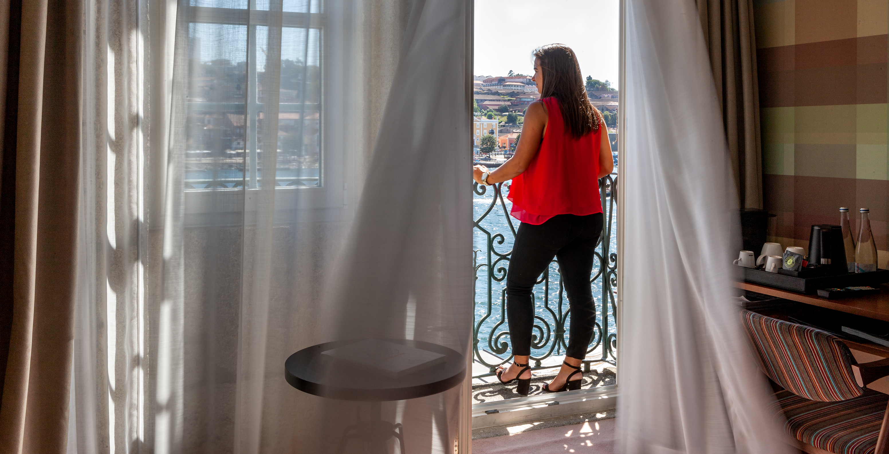The Vintage River View Balcony room at Pestana Vintage Porto has a large window with balcony and view of the Douro River