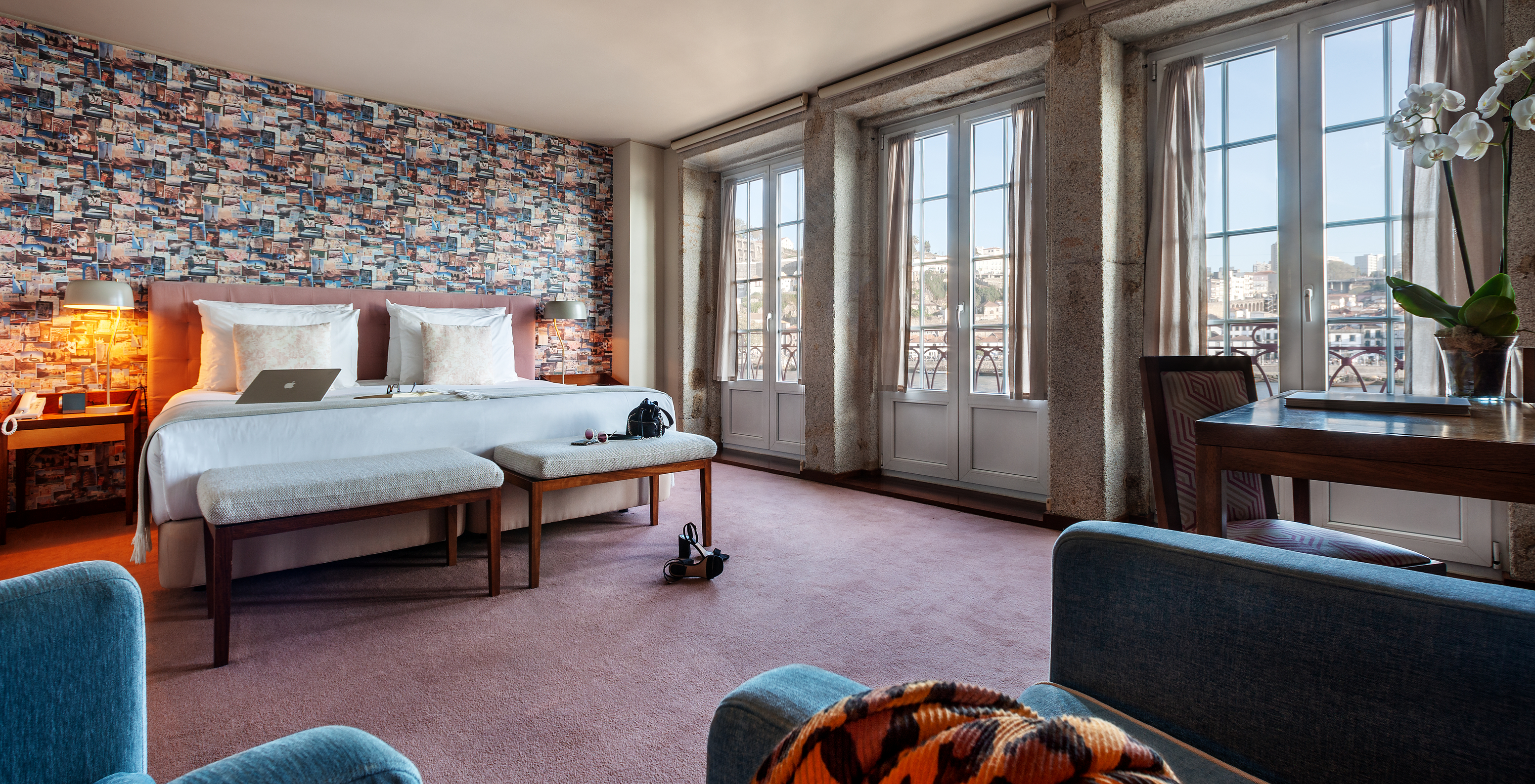 The Grand View Suite at Pestana Vintage Porto has a double bed, with wallpaper with images of travel and sofas