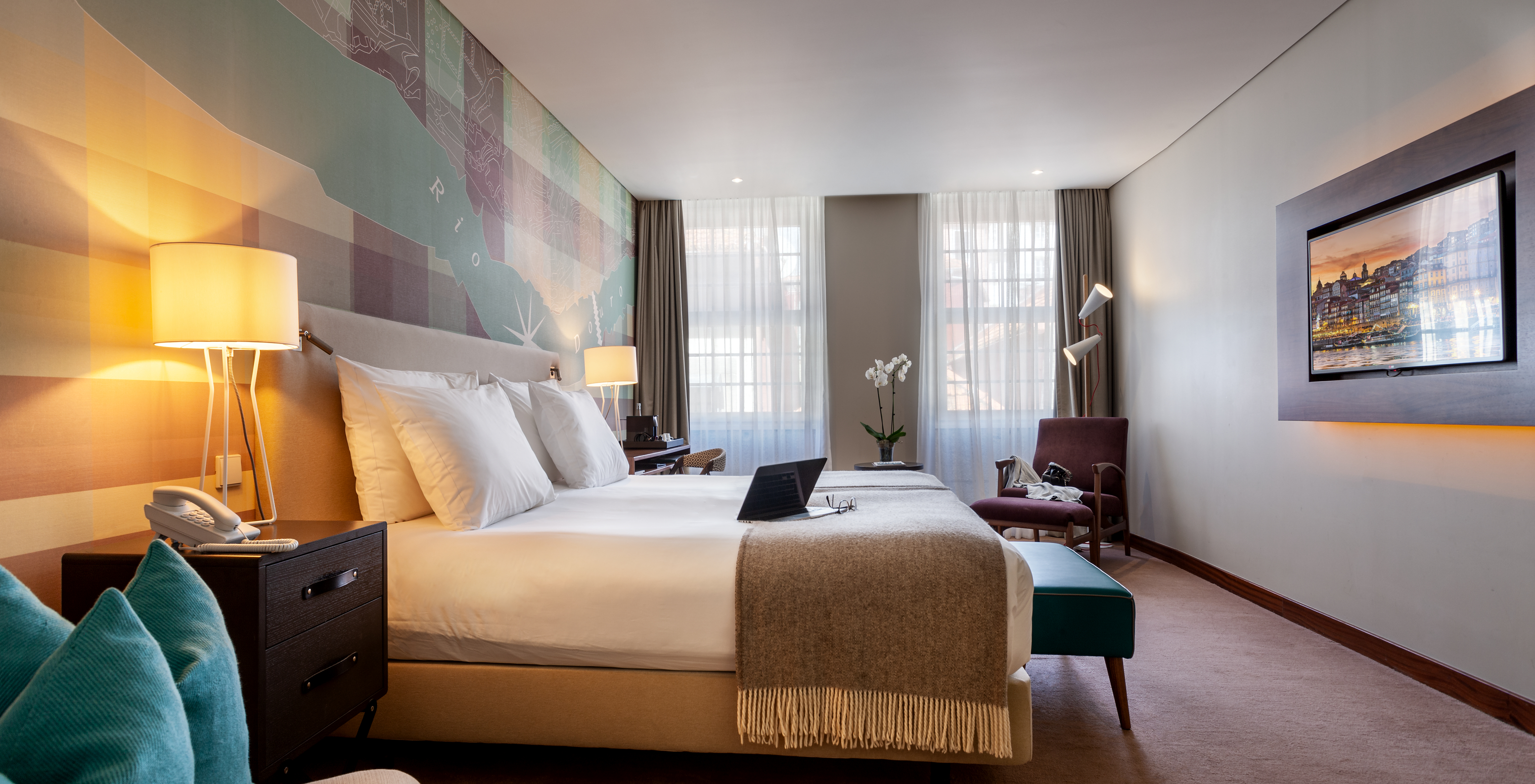 The Superior room at Pestana Vintage Porto has a double bed with a bench at the foot, bedside table and an armchair