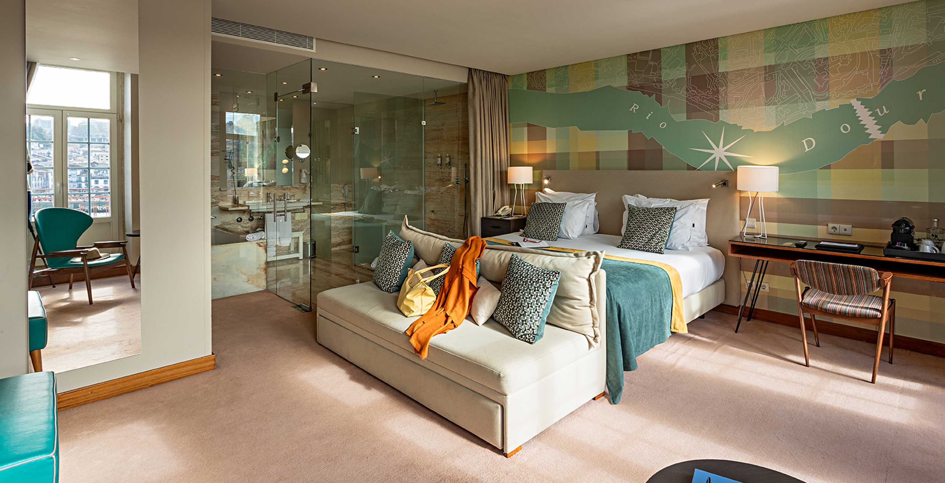 The Vintage Grand View Balcony room at Pestana Vintage Porto has a double bed with a sofa, three windows and an armchair