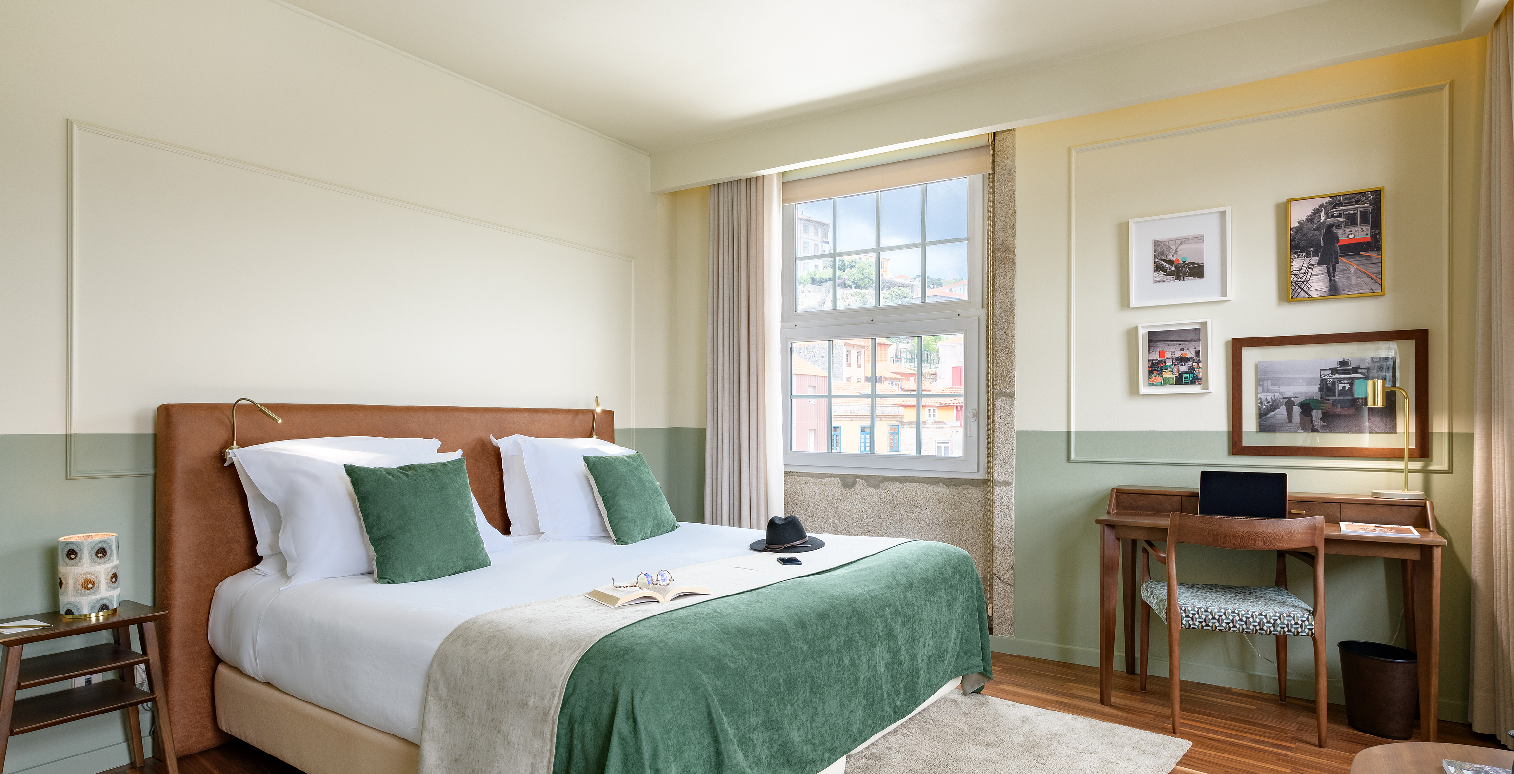 The Vintage Grand View room at Pestana Vintage Porto has a double bed with a green bedspread, a desk and large windows
