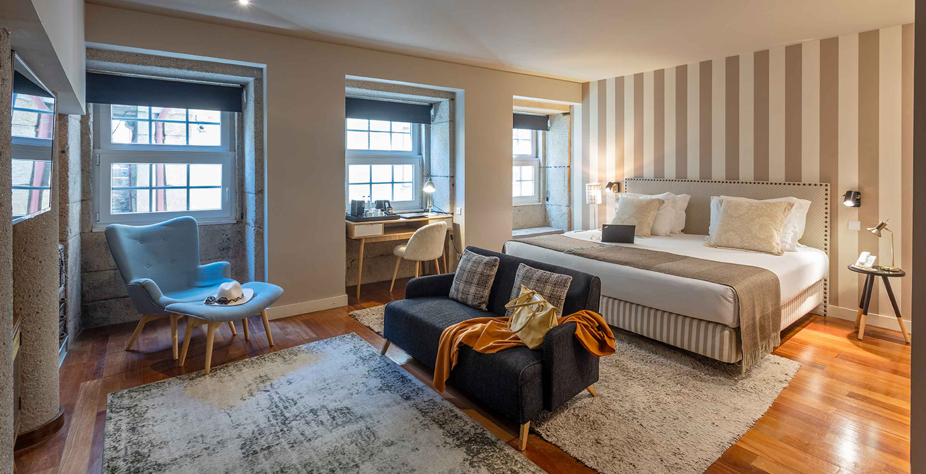 The Heritage Suite at Pestana Vintage Porto has a bathtub in the middle of the room, a seating area with a radio and sofas