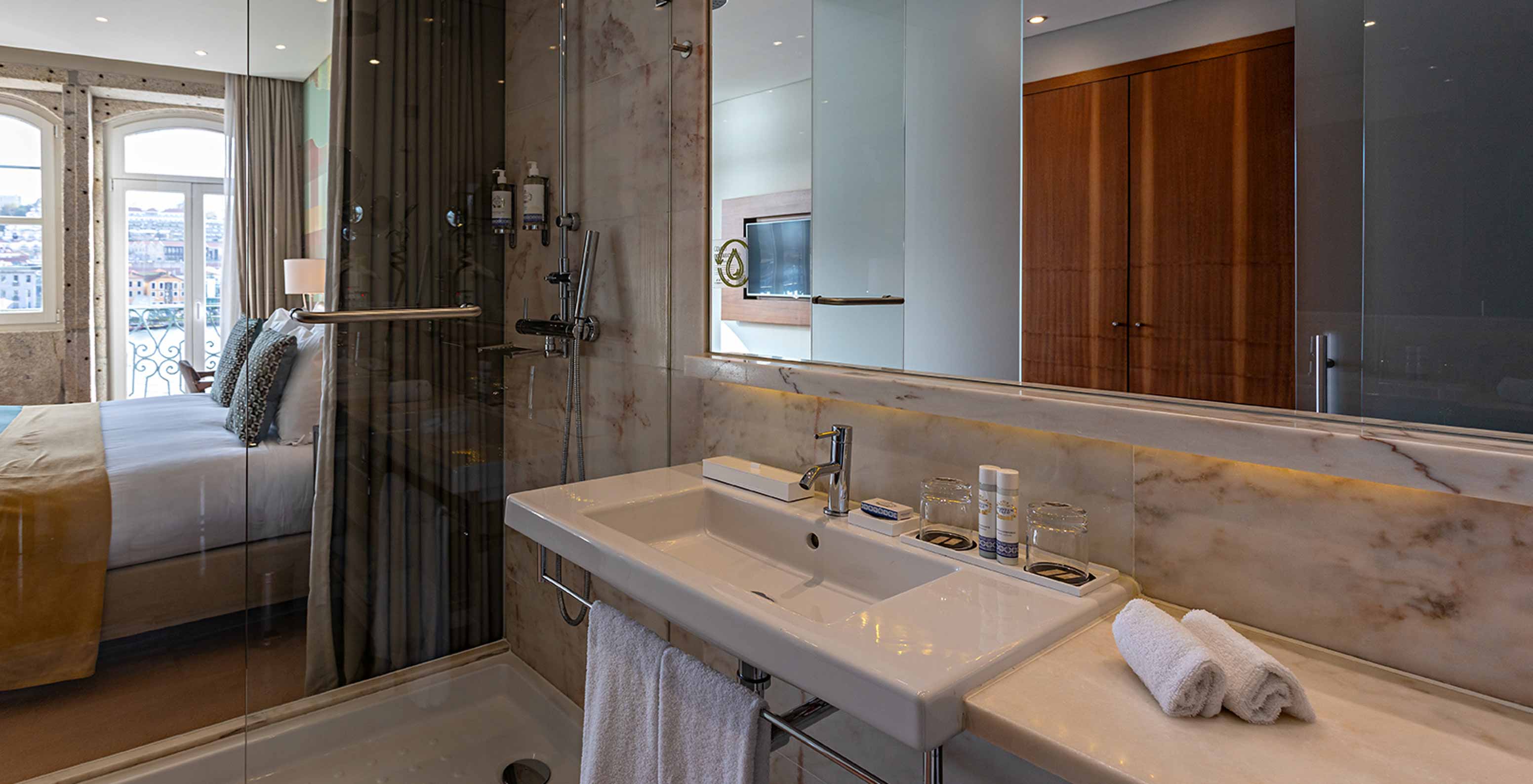 The Vintage River View Balcony room at Pestana Vintage Porto has a bathroom with shower and view of the double bed